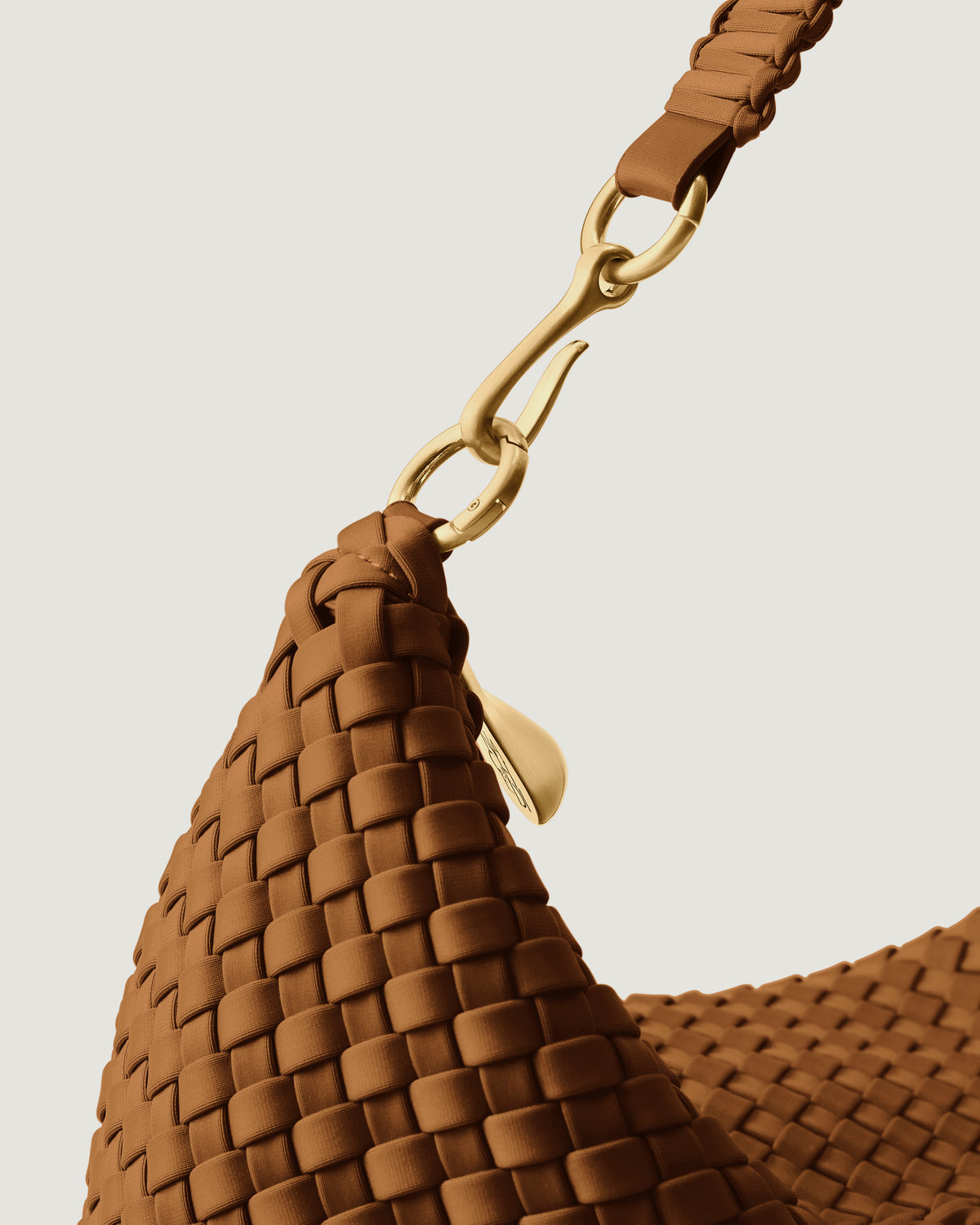 Close-up of zip closure and custom brushed gold strap hardware.