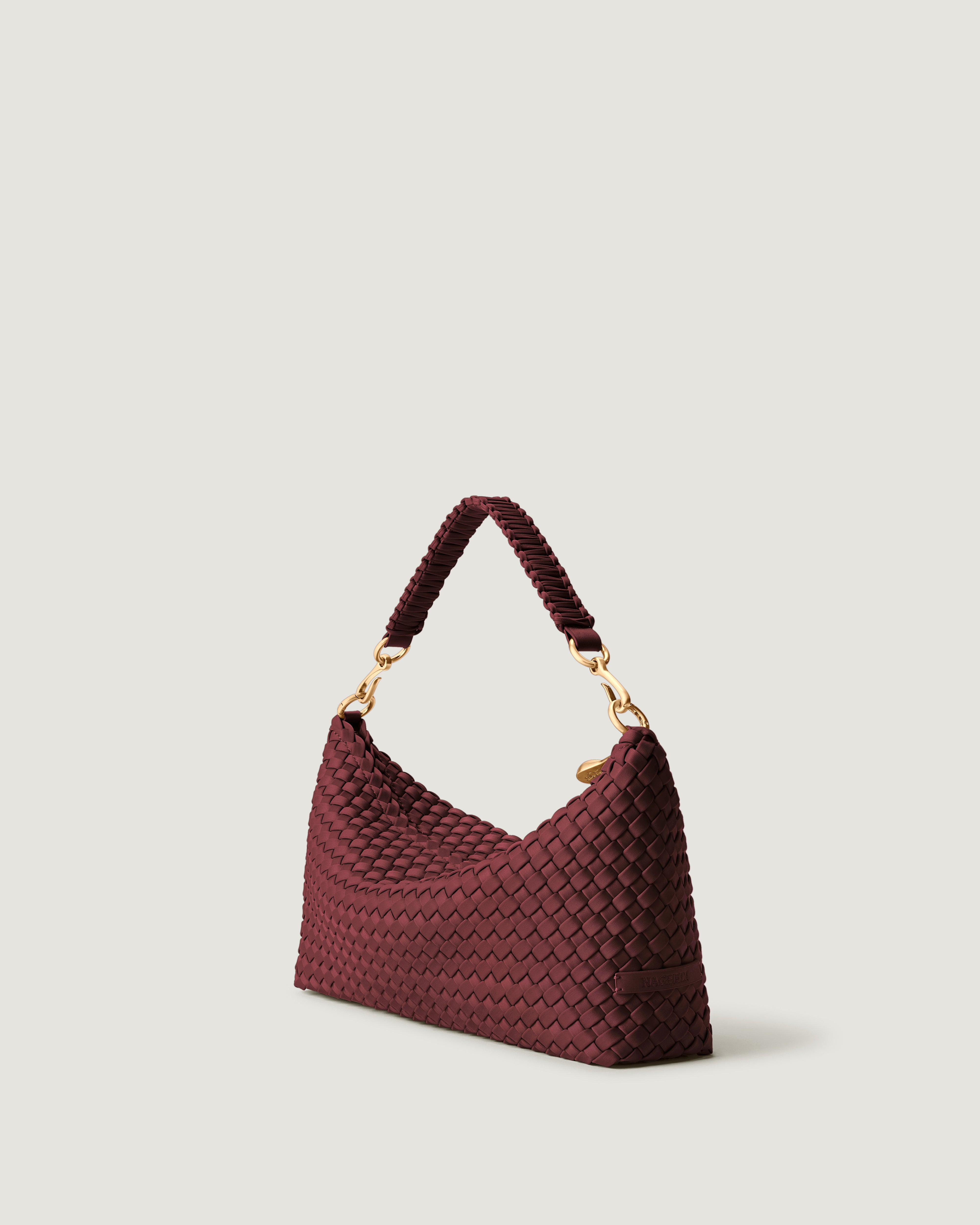 Porto Half-Moon in Bordeaux shown from a side angle, highlighting its handwoven neoprene construction and zip closure.