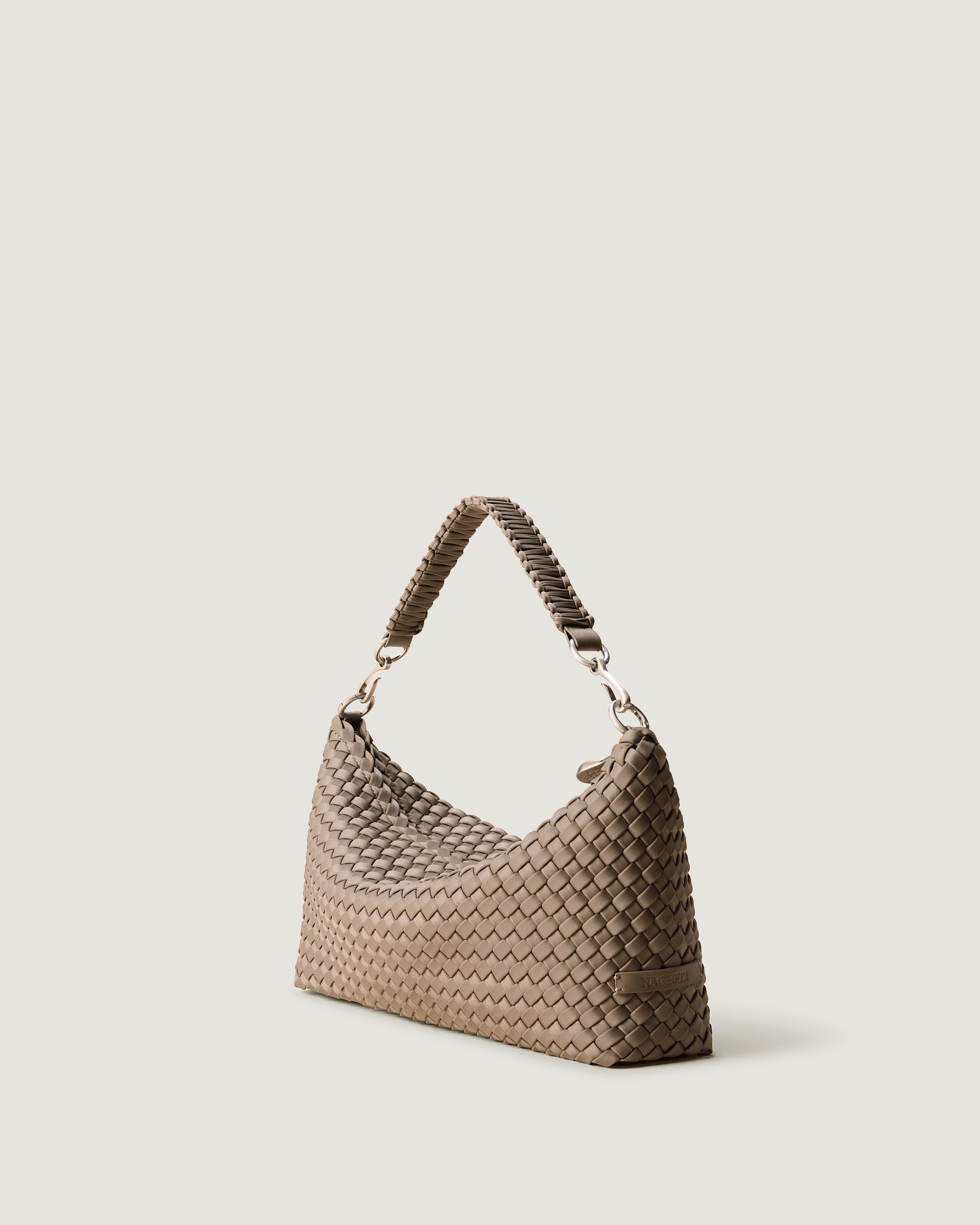 Porto Half-Moon in Cashmere shown from a side angle, highlighting its handwoven neoprene construction and zip closure.