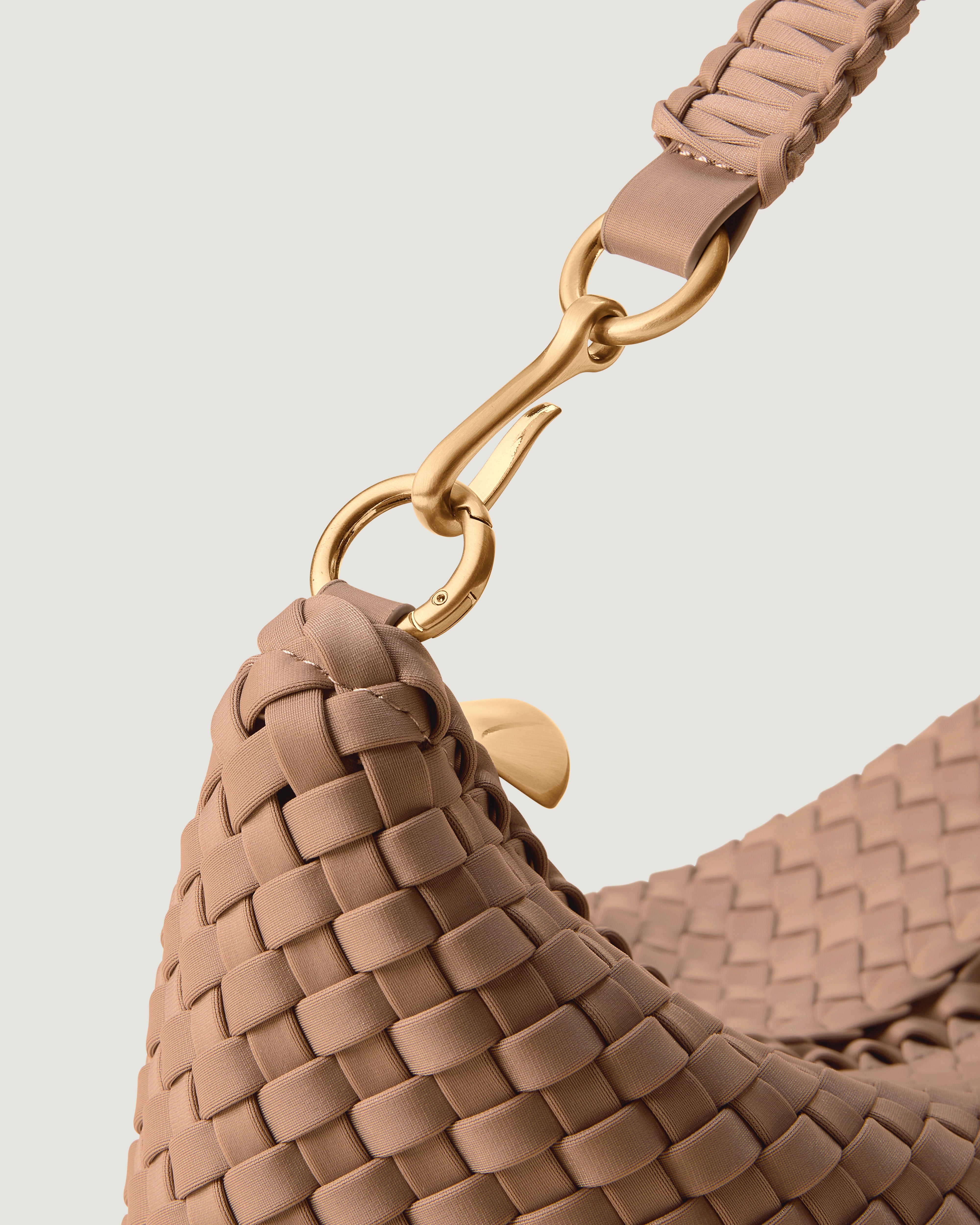 Close-up of zip closure and custom brushed gold strap hardware.