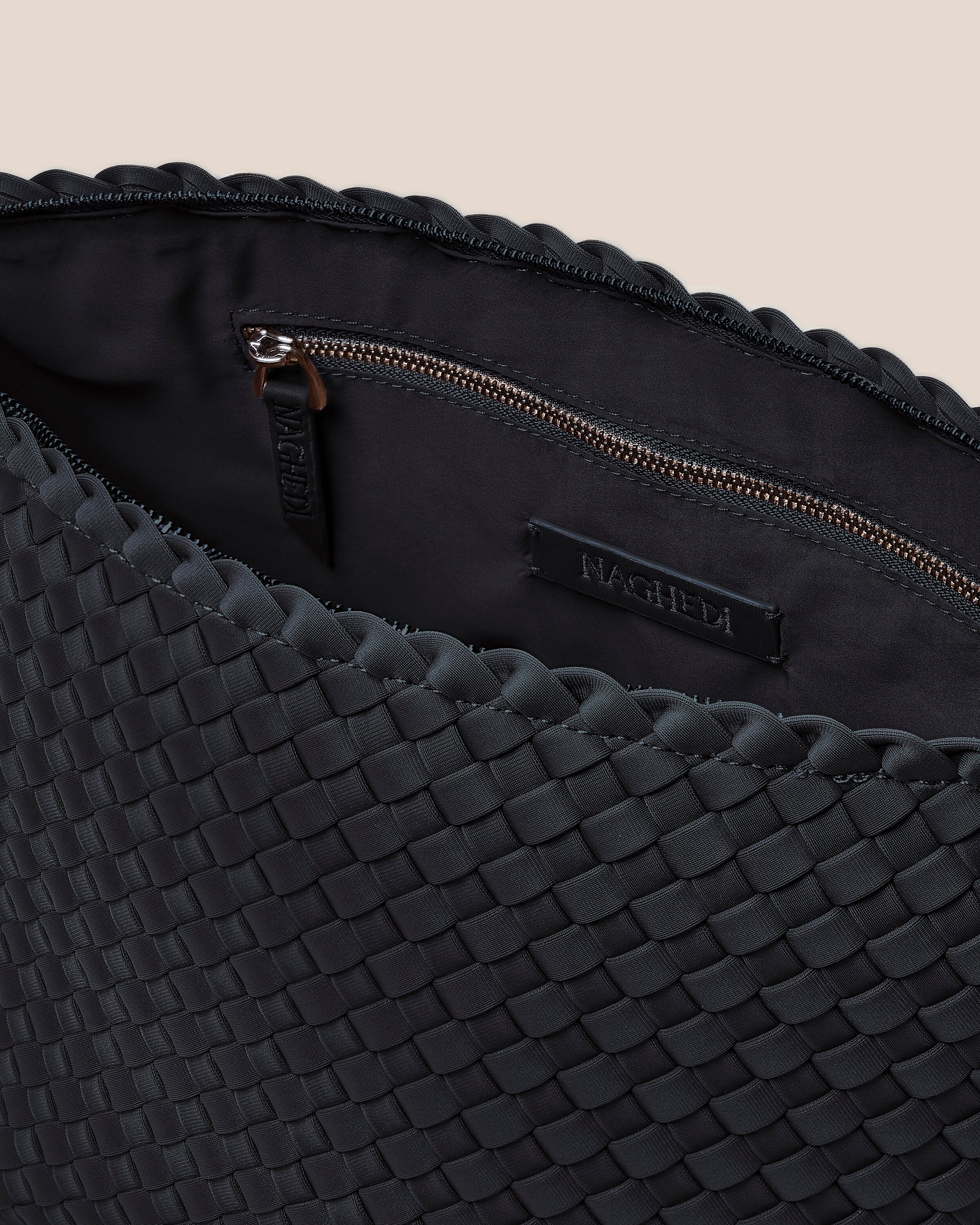 Interior close-up of Portofino Cosmetic Pouch in Onyx showing its zip closure, interior pockets, and wipe-clean nylon interior.