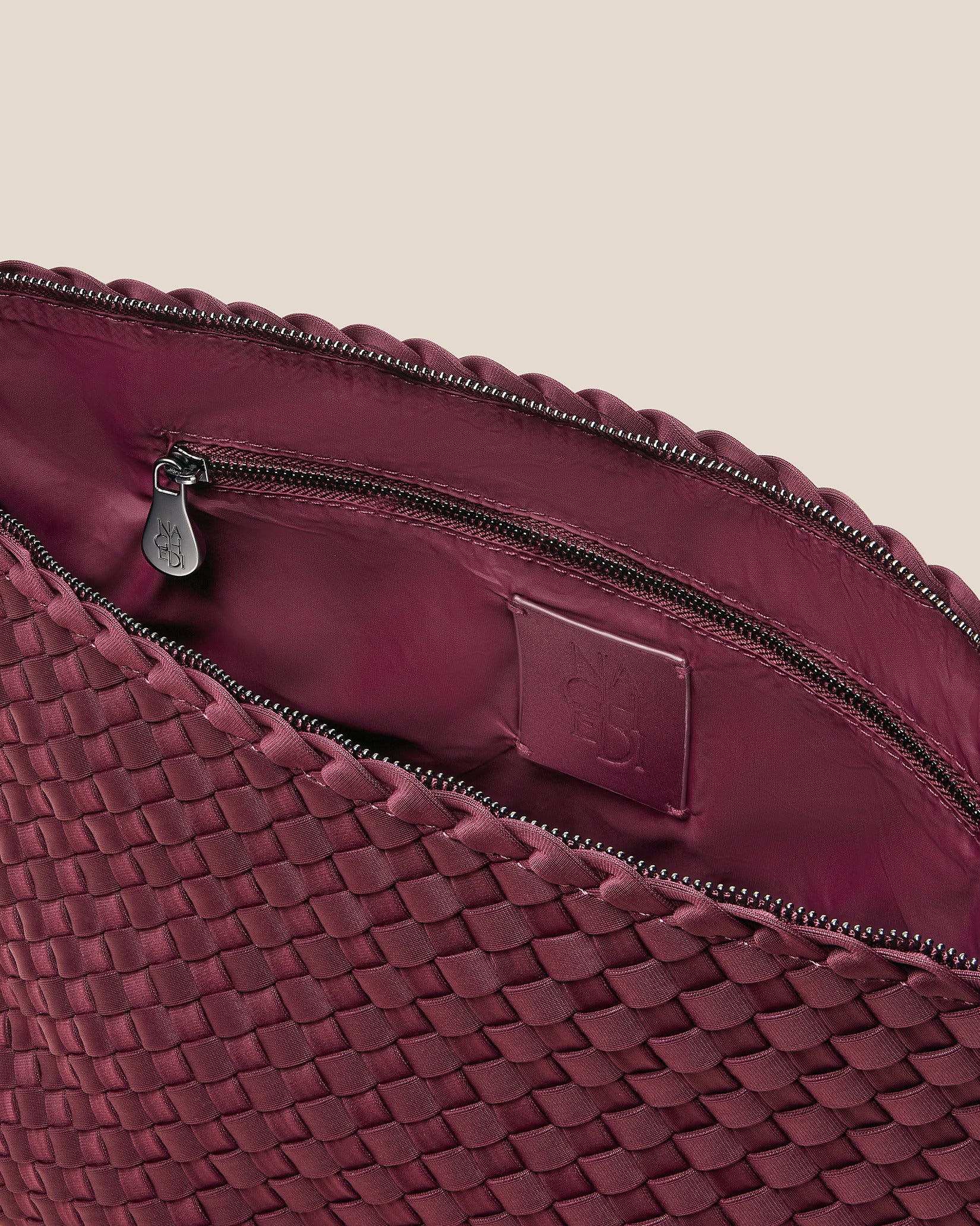 Interior close-up of Portofino Large Cosmetic Pouch in Bordeaux showing its zip closure, interior pockets, and wipe-clean nylon interior.