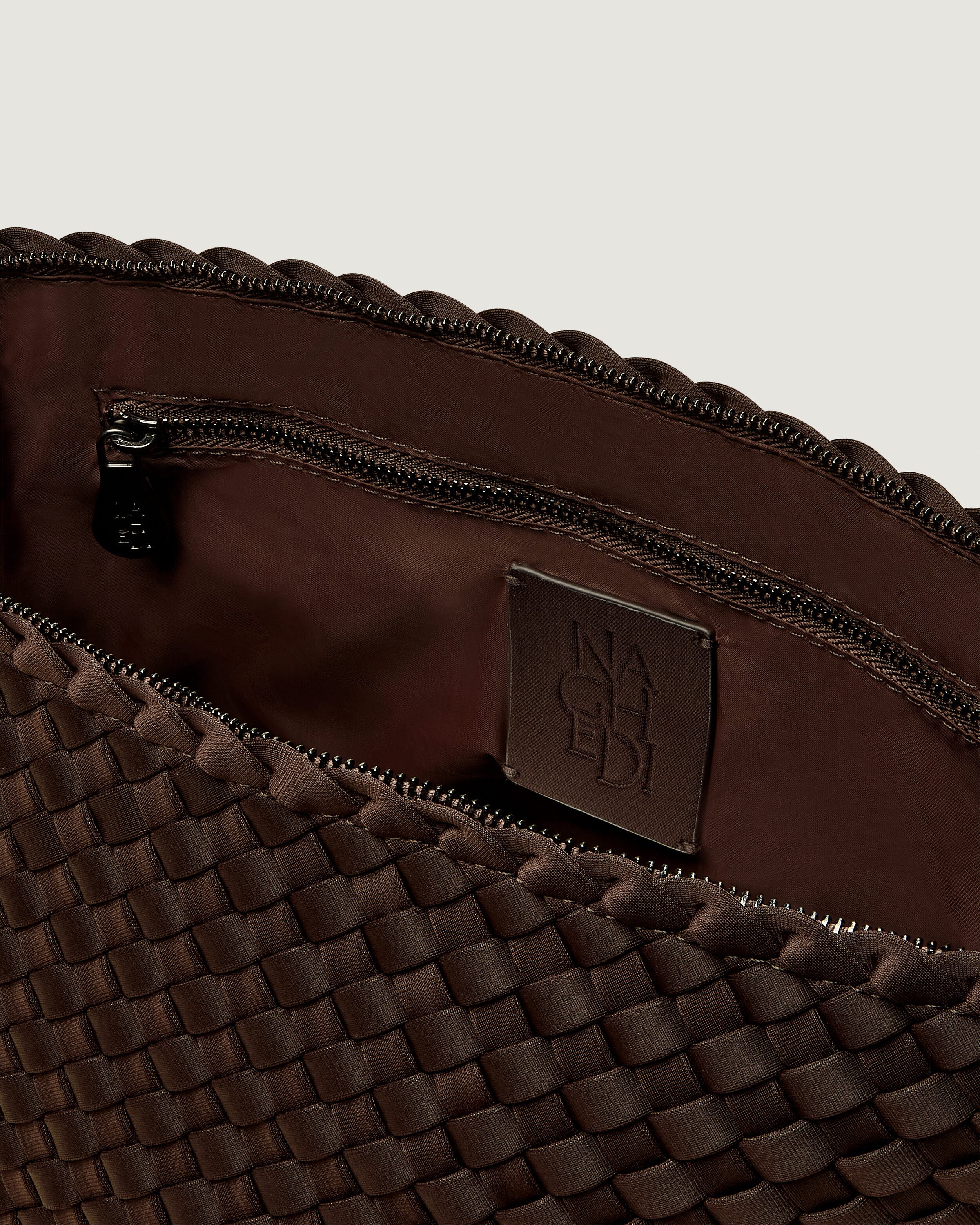 Interior close-up of Portofino Cosmetic Pouch in Chocolate showing its zip closure, interior pockets, and wipe-clean nylon interior.