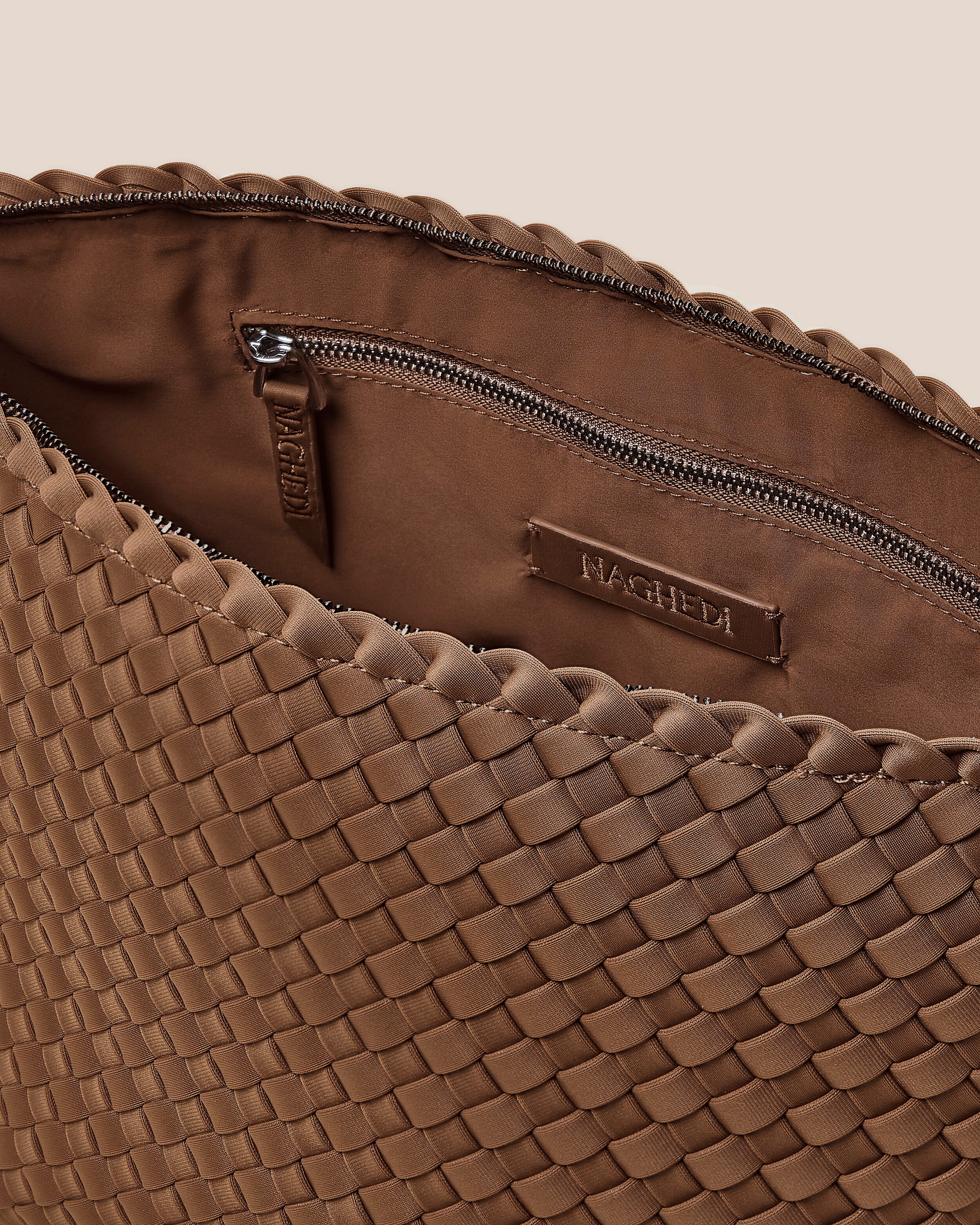 Interior close-up of Portofino Cosmetic Pouch in Mink showing its zip closure, interior pockets, and wipe-clean nylon interior.