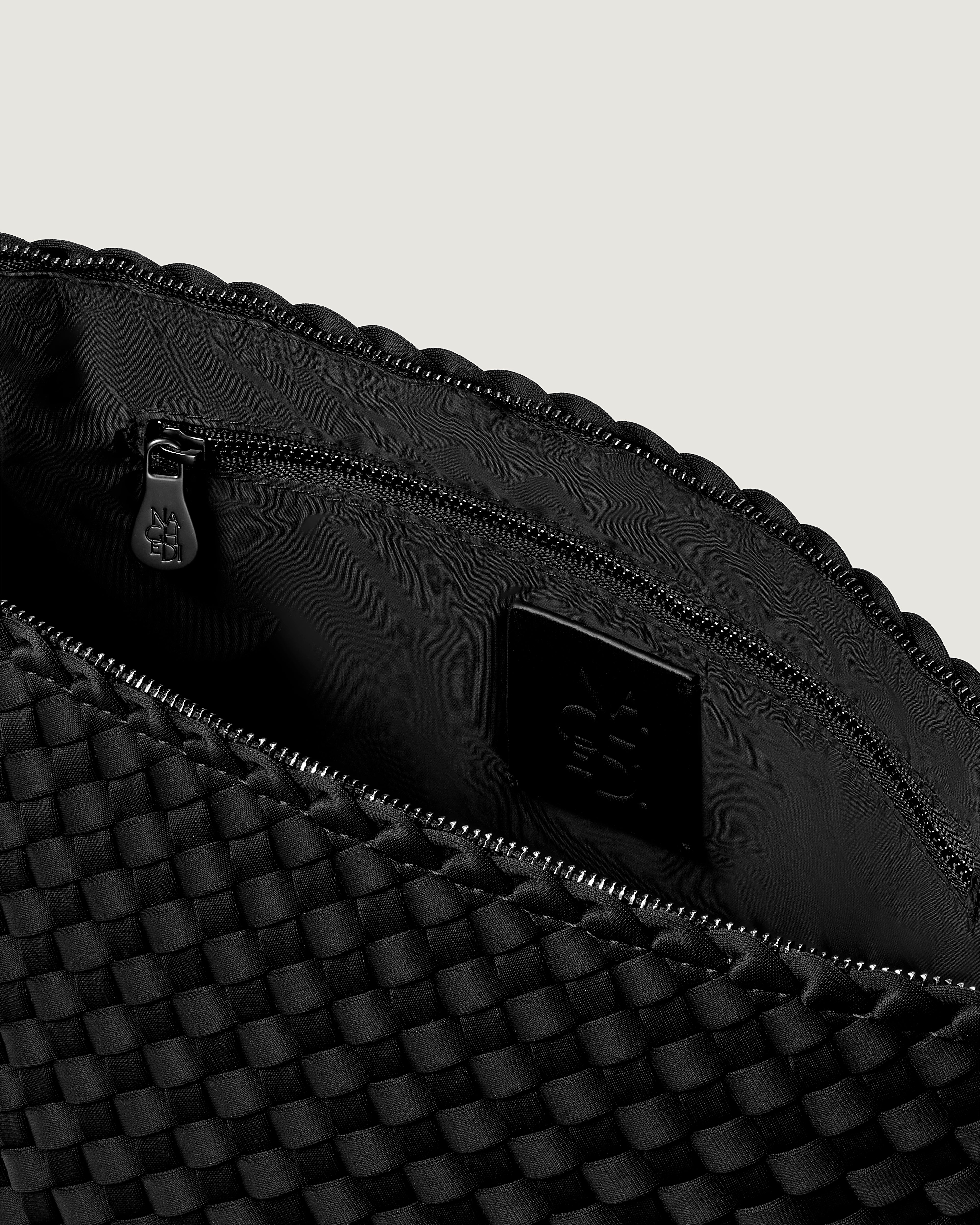 Interior close-up of Portofino Cosmetic Pouch in Onyx showing its zip closure, interior pockets, and wipe-clean nylon interior.