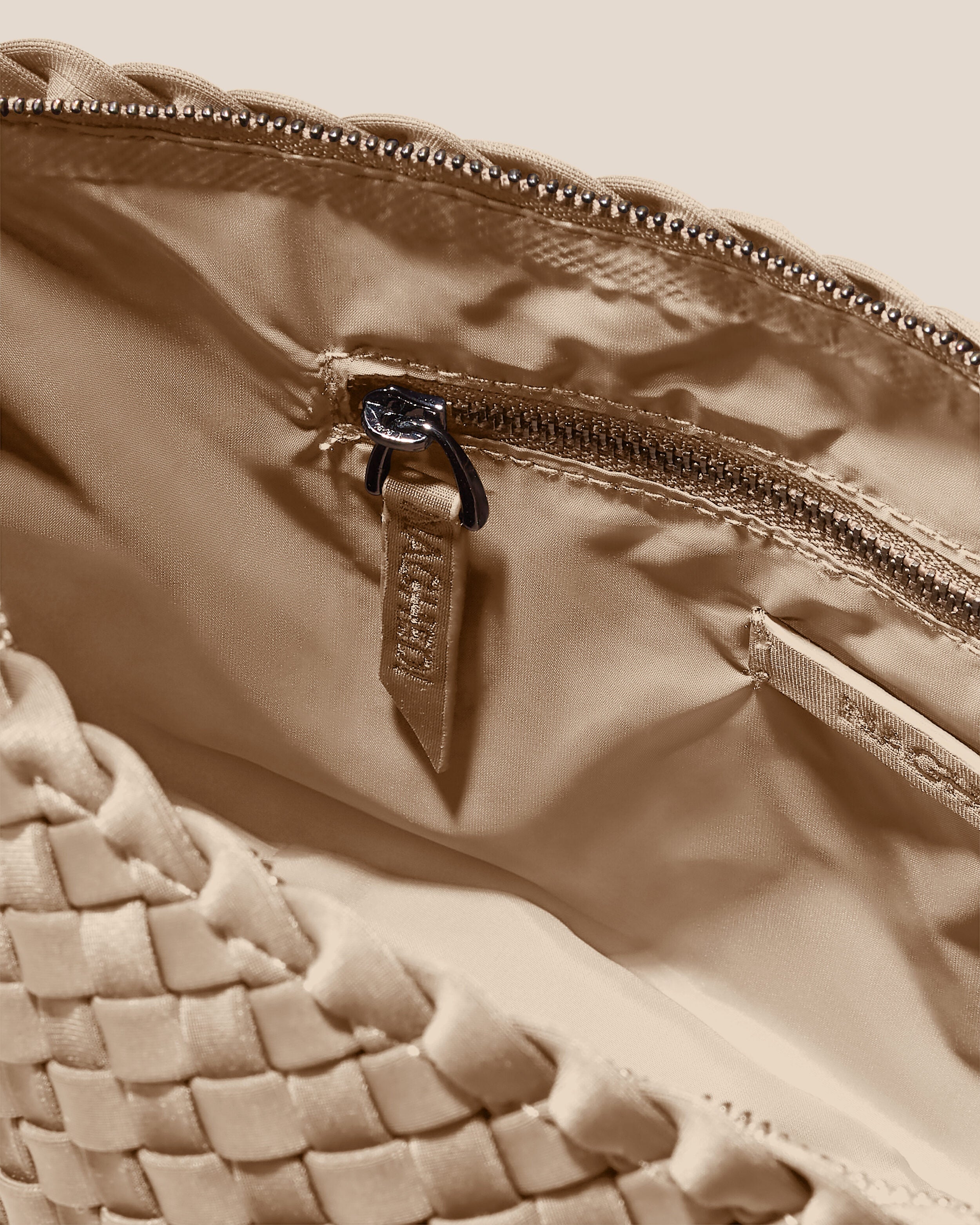 Interior close-up of Portofino Cosmetic Pouch in Cashmere showing its zip closure, interior pockets, and wipe-clean nylon interior.