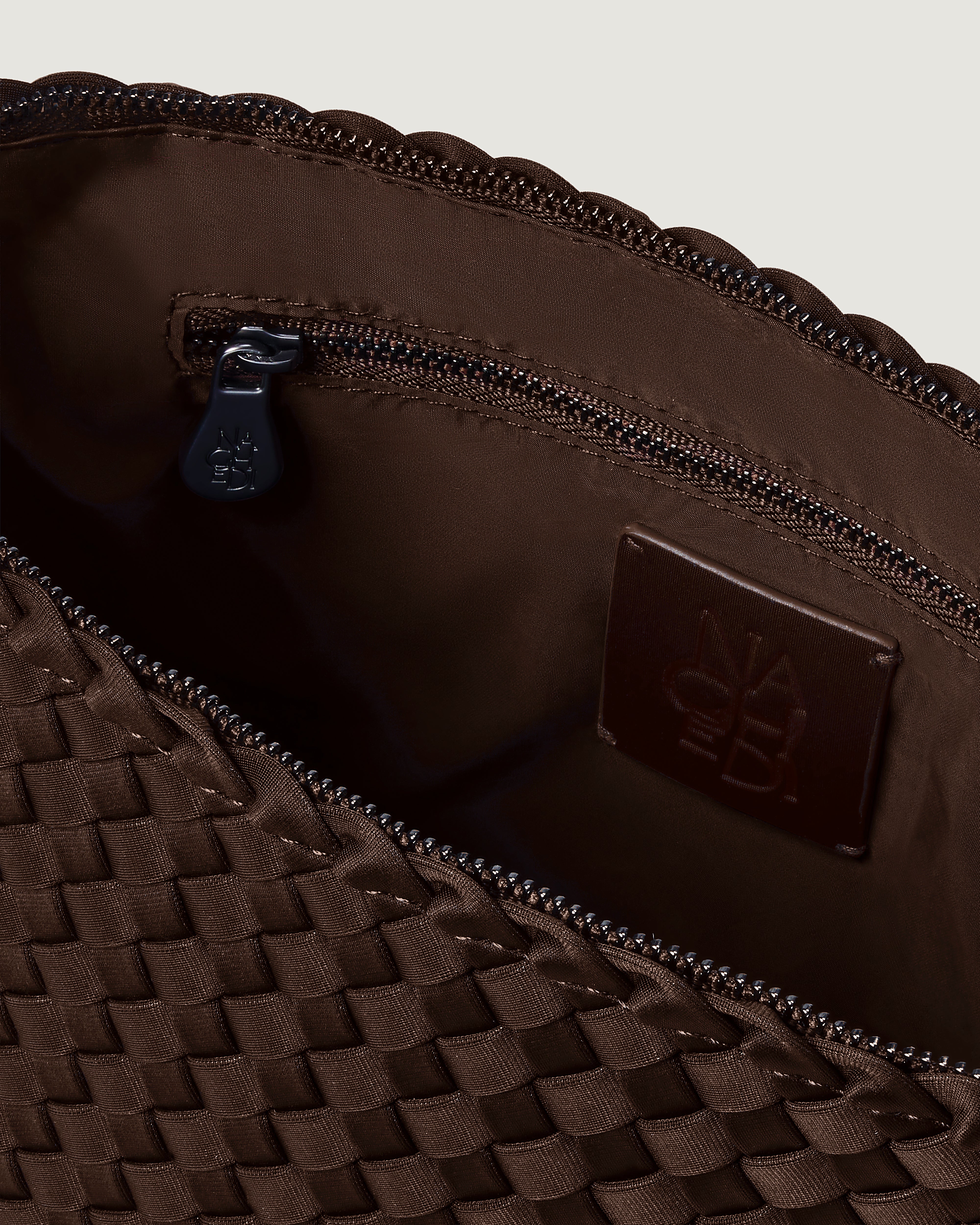Interior close-up of Portofino Cosmetic Pouch in Chocolate showing its zip closure, interior pockets, and wipe-clean nylon interior.