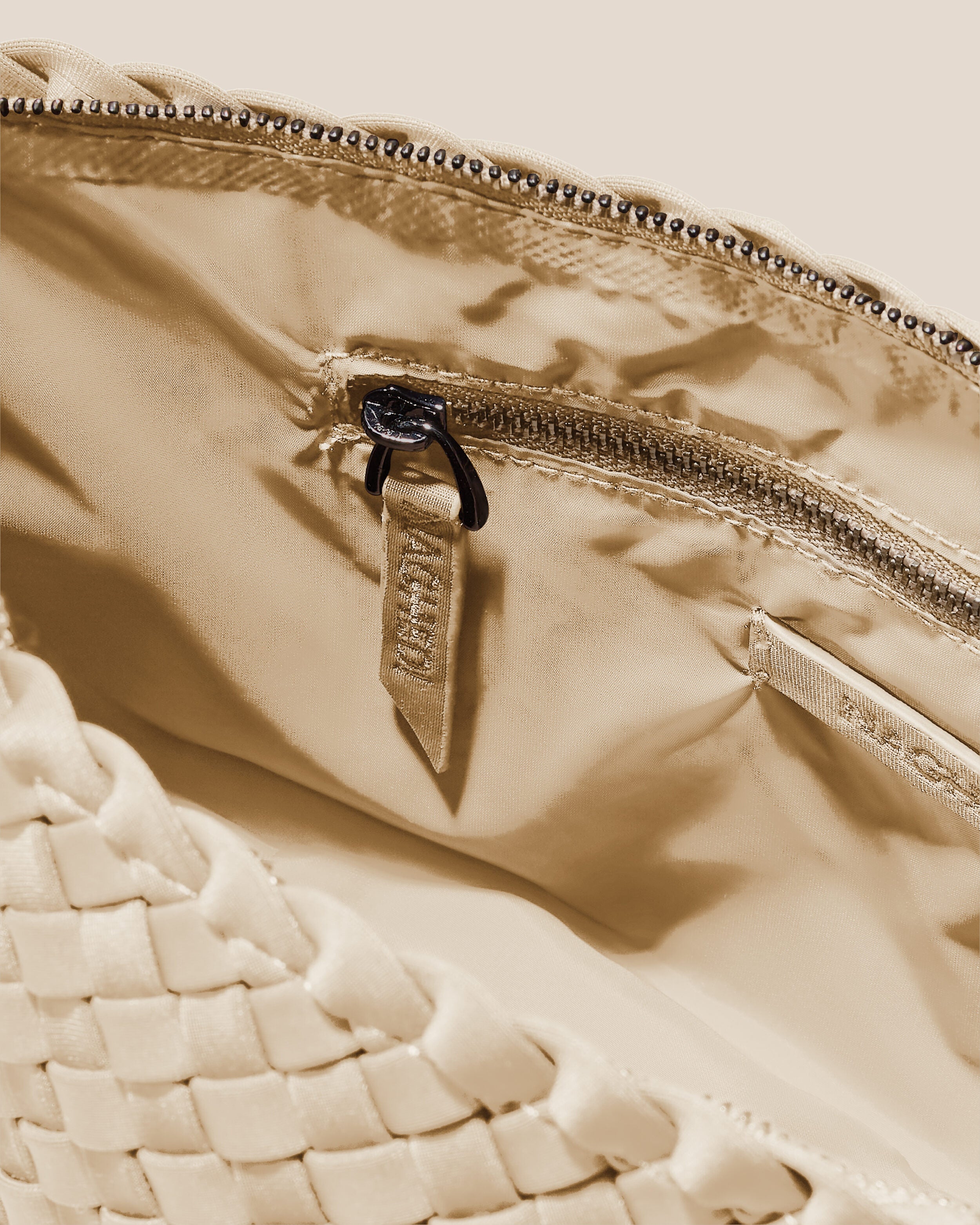 Interior close-up of Portofino Cosmetic Pouch in Ecru showing its zip closure, interior pockets, and wipe-clean nylon interior.