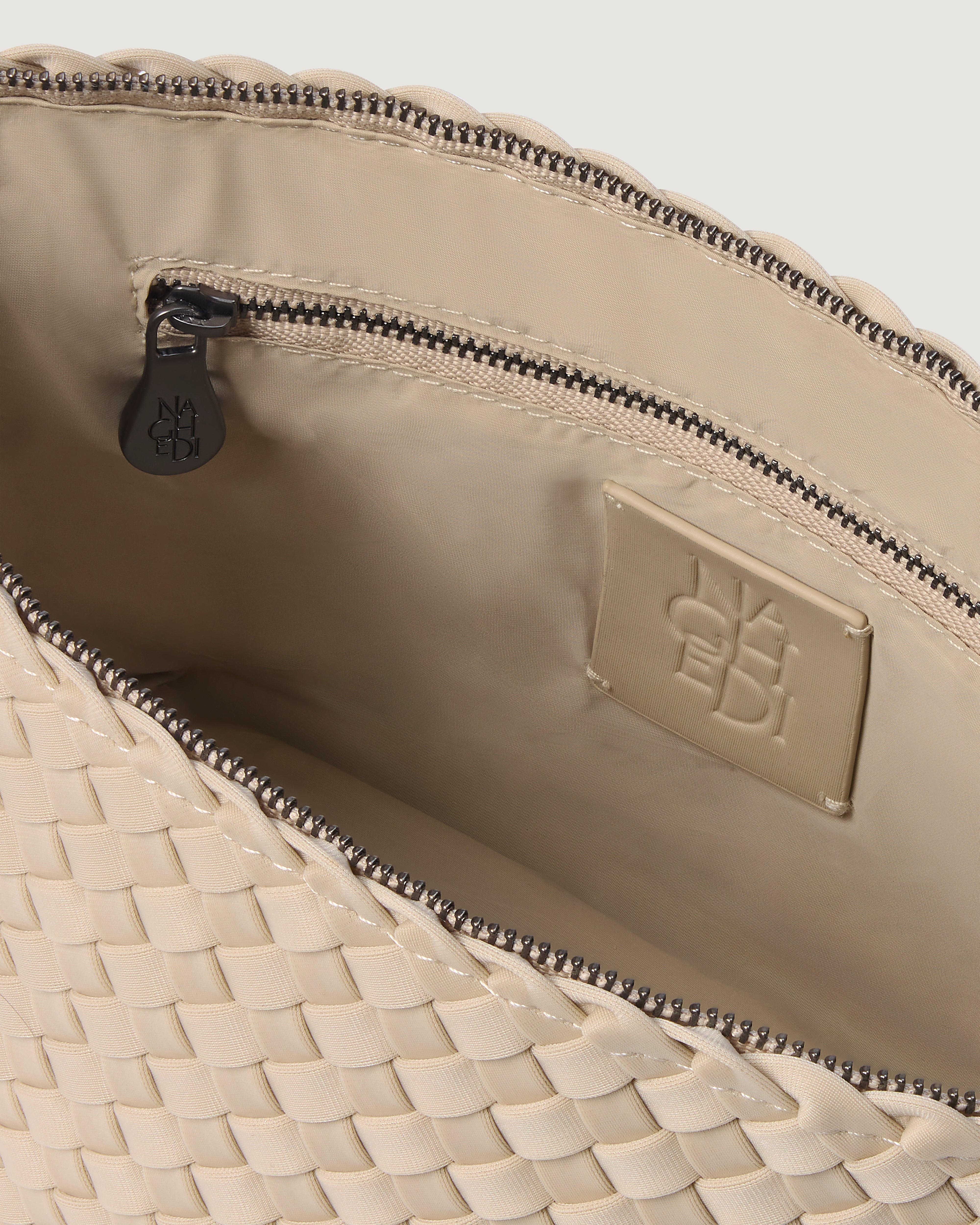 Interior close-up of Portofino Cosmetic Pouch in Ecru showing its zip closure, interior pockets, and wipe-clean nylon interior.