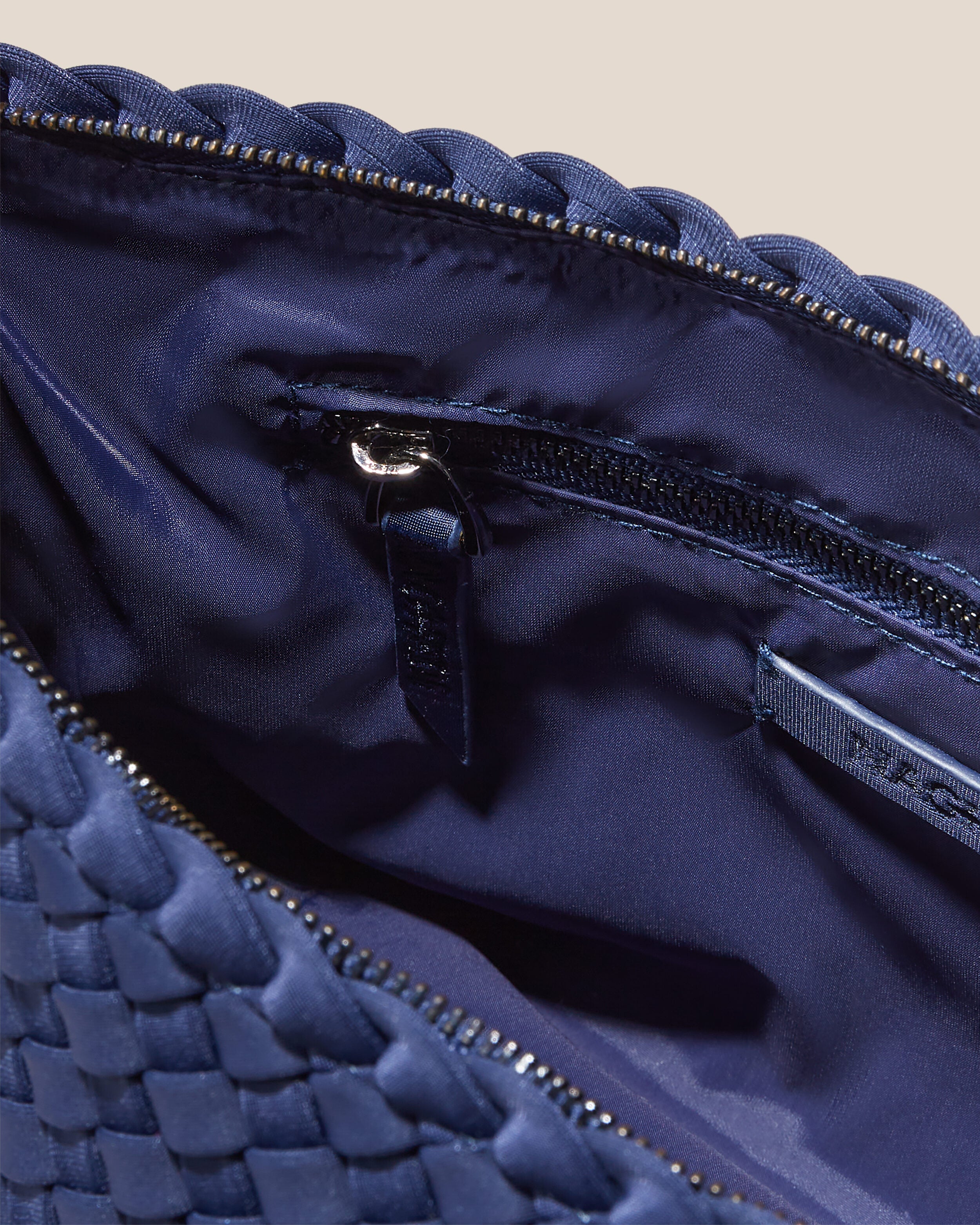 Interior close-up of Portofino Cosmetic Pouch in Ink Blue showing its zip closure, interior pockets, and wipe-clean nylon interior.