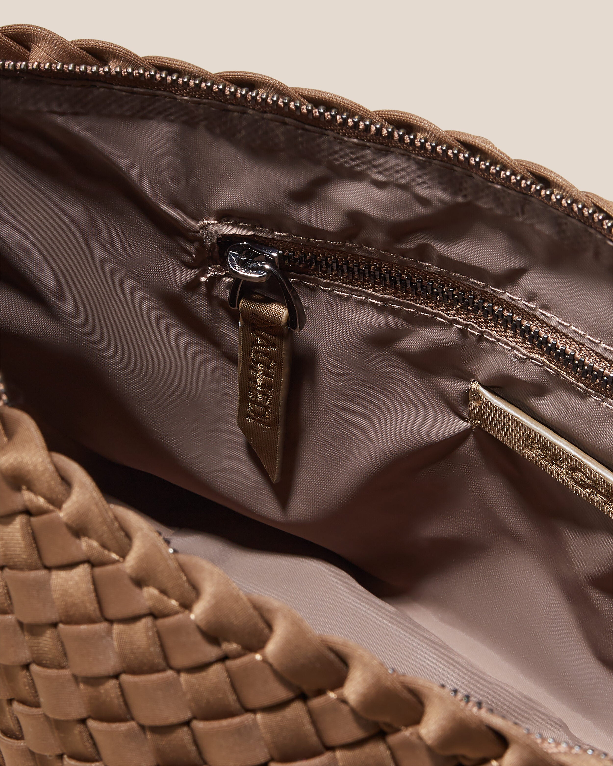 Interior close-up of Portofino Cosmetic Pouch in Mink showing its zip closure, interior pockets, and wipe-clean nylon interior.