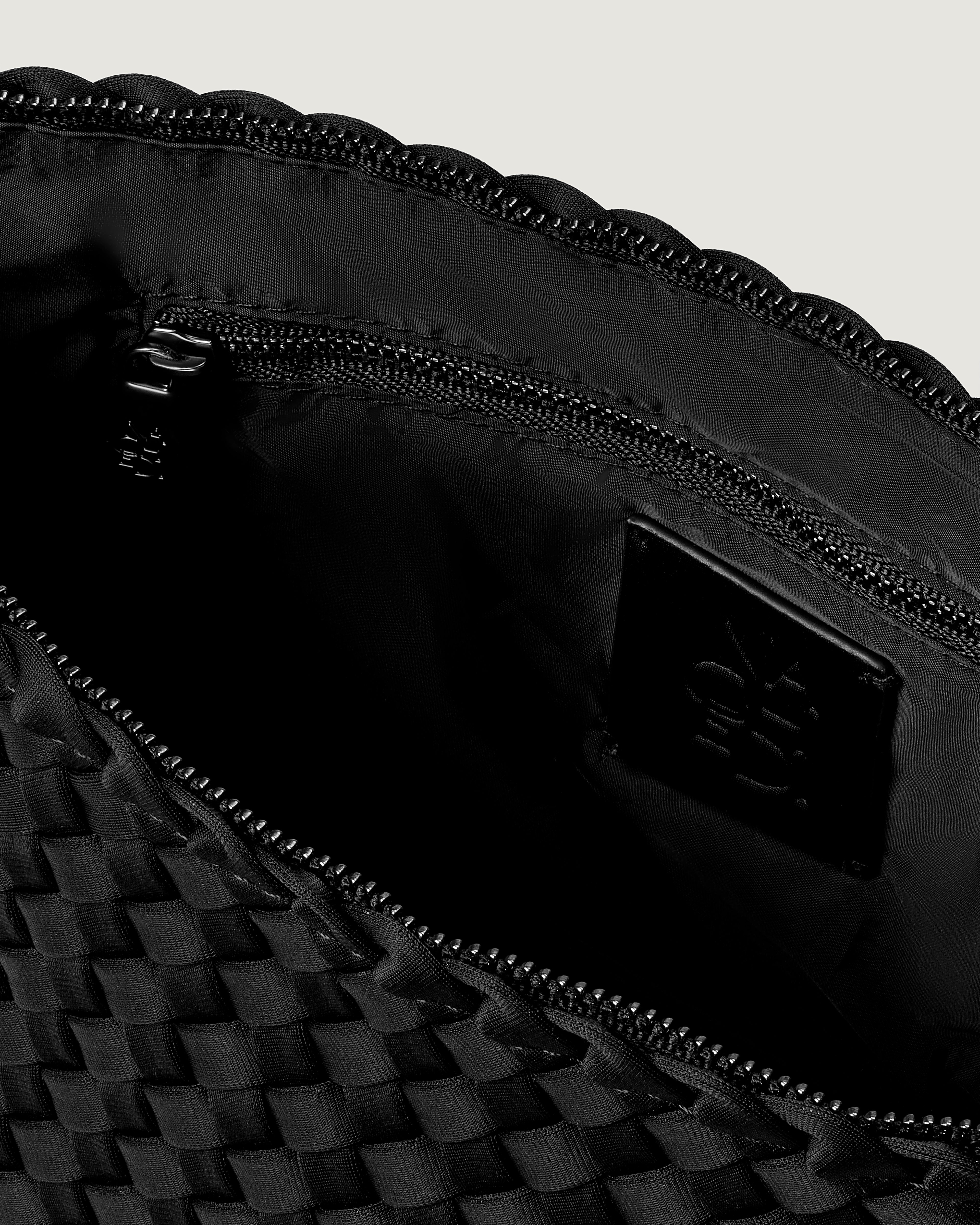 Interior close-up of Portofino Cosmetic Pouch in Onyx showing its zip closure, interior pockets, and wipe-clean nylon interior.