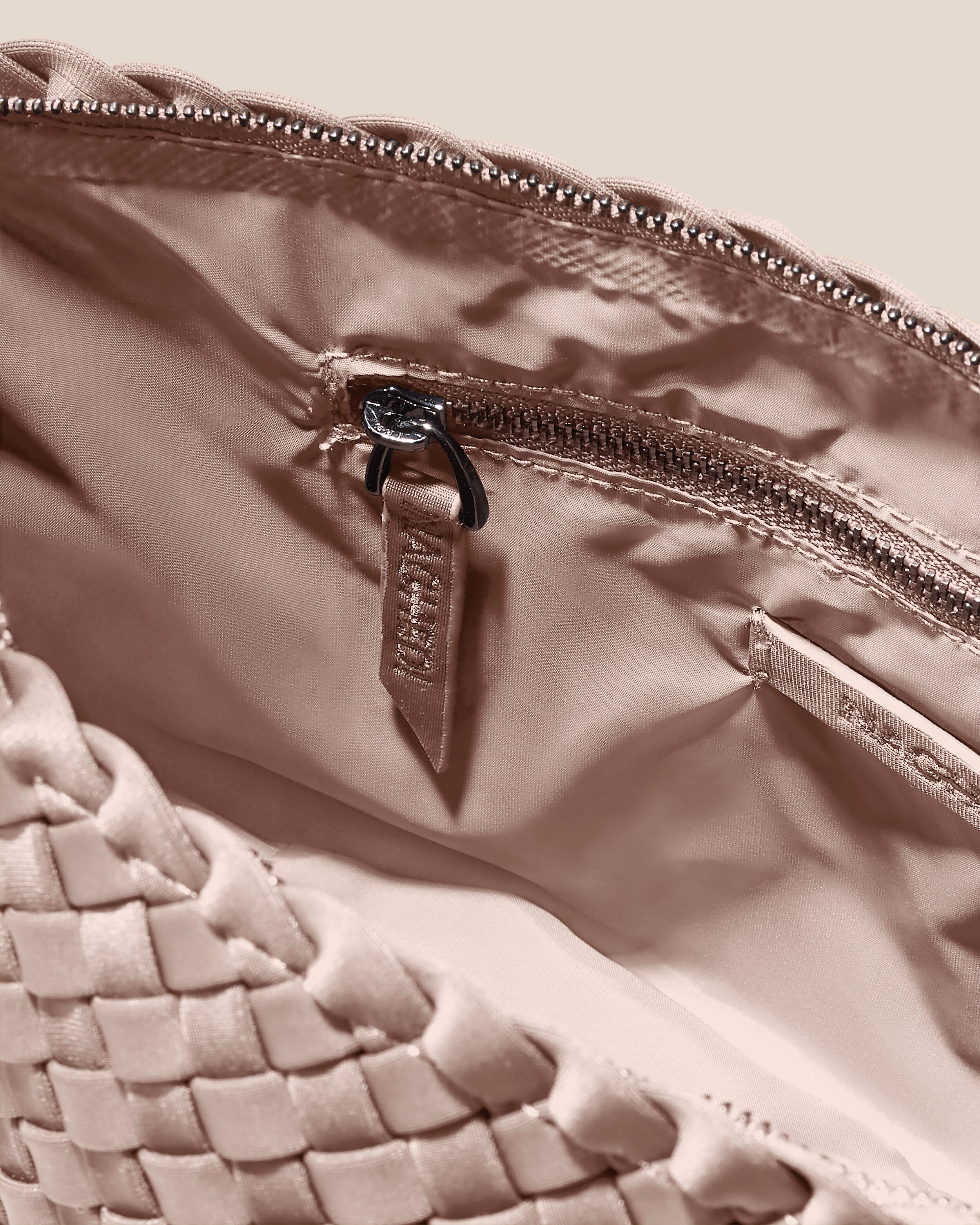 Interior close-up of Portofino Cosmetic Pouch in Shell Pink showing its zip closure, interior pockets, and wipe-clean nylon interior.