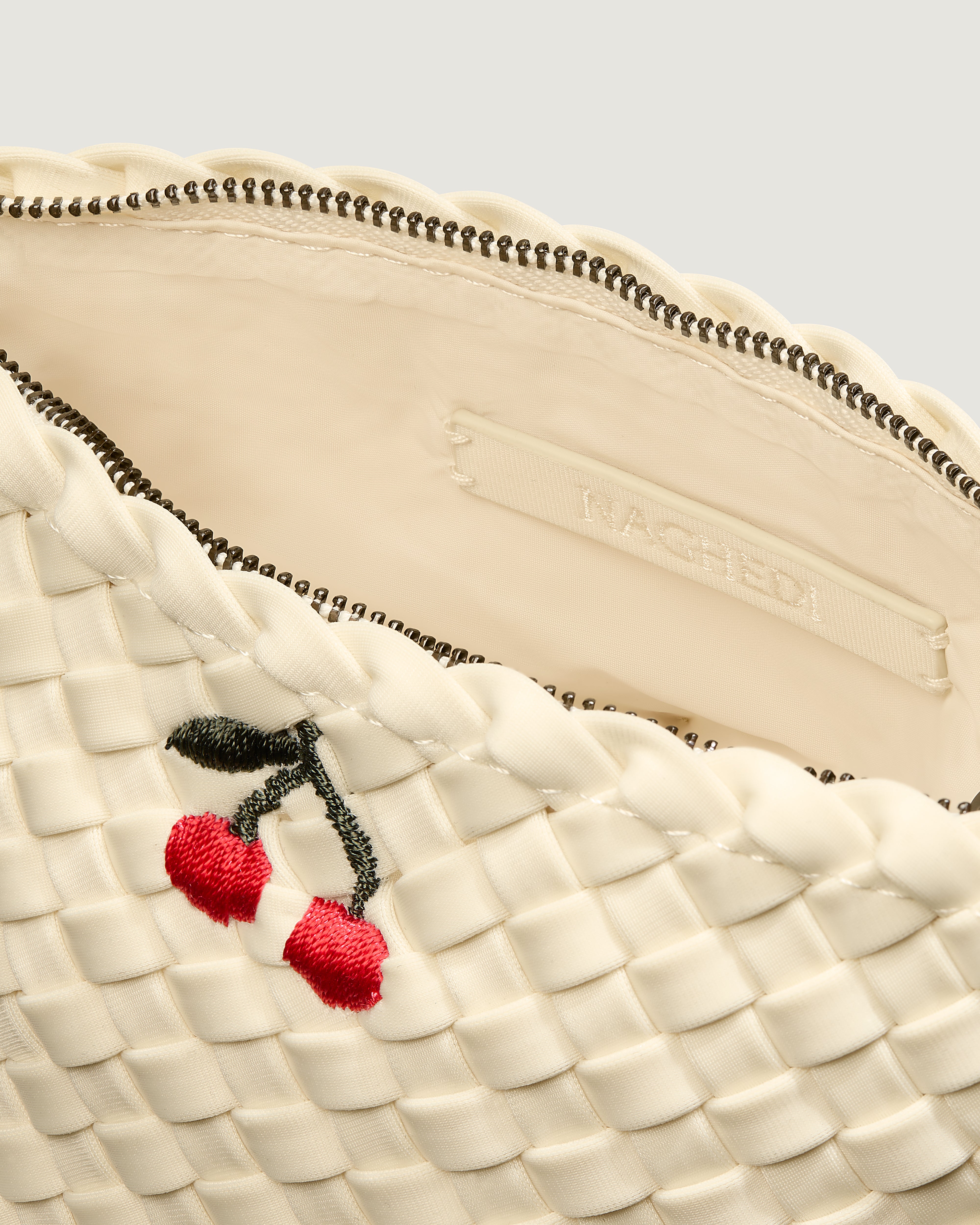 Interior close-up of Portofino Cosmetic Pouch in Salt showing its zip closure, interior pockets, and wipe-clean nylon interior.