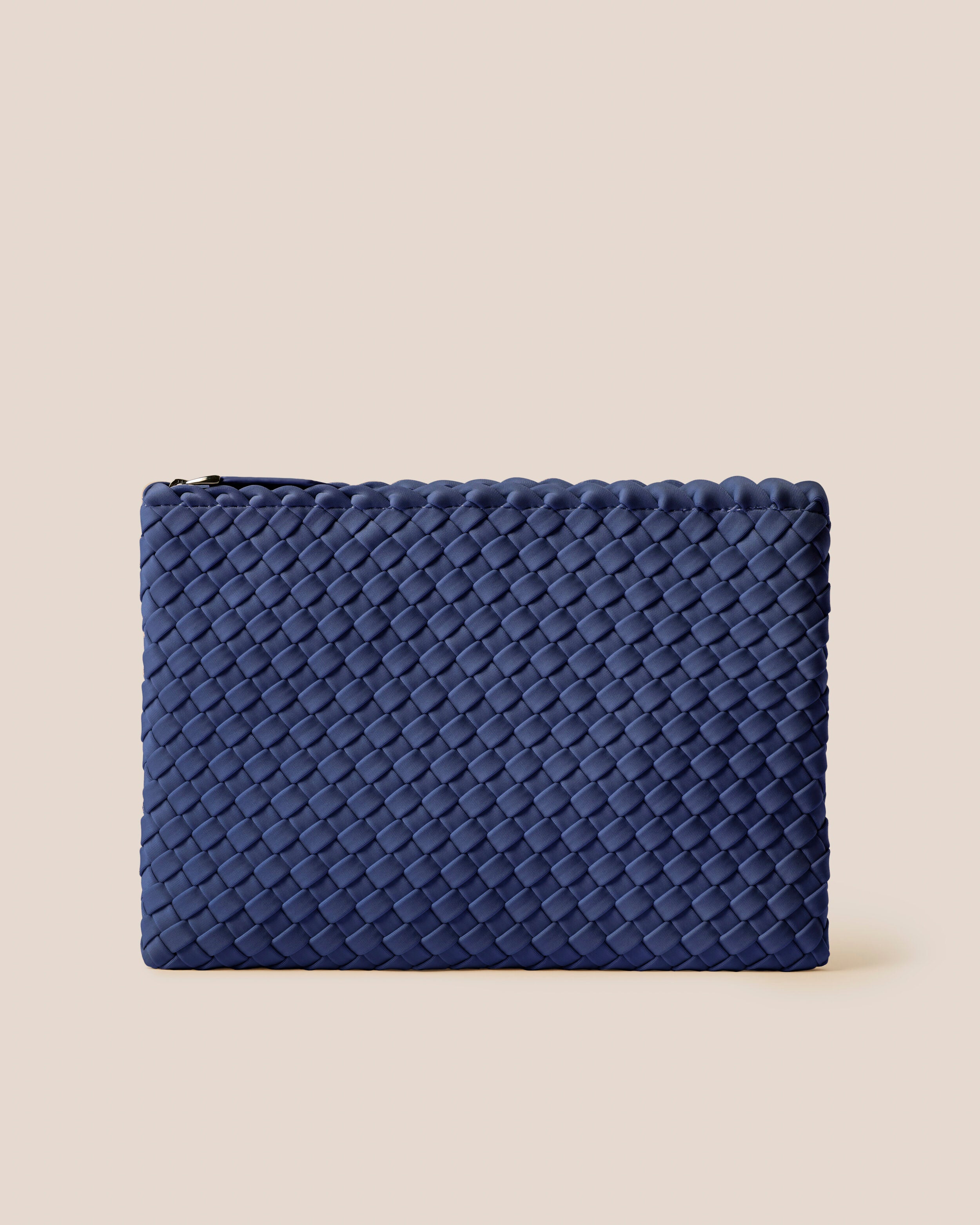 Salina Pouch in Ink Blue, a navy blue tone, in handwoven neoprene, featuring a zip closure.