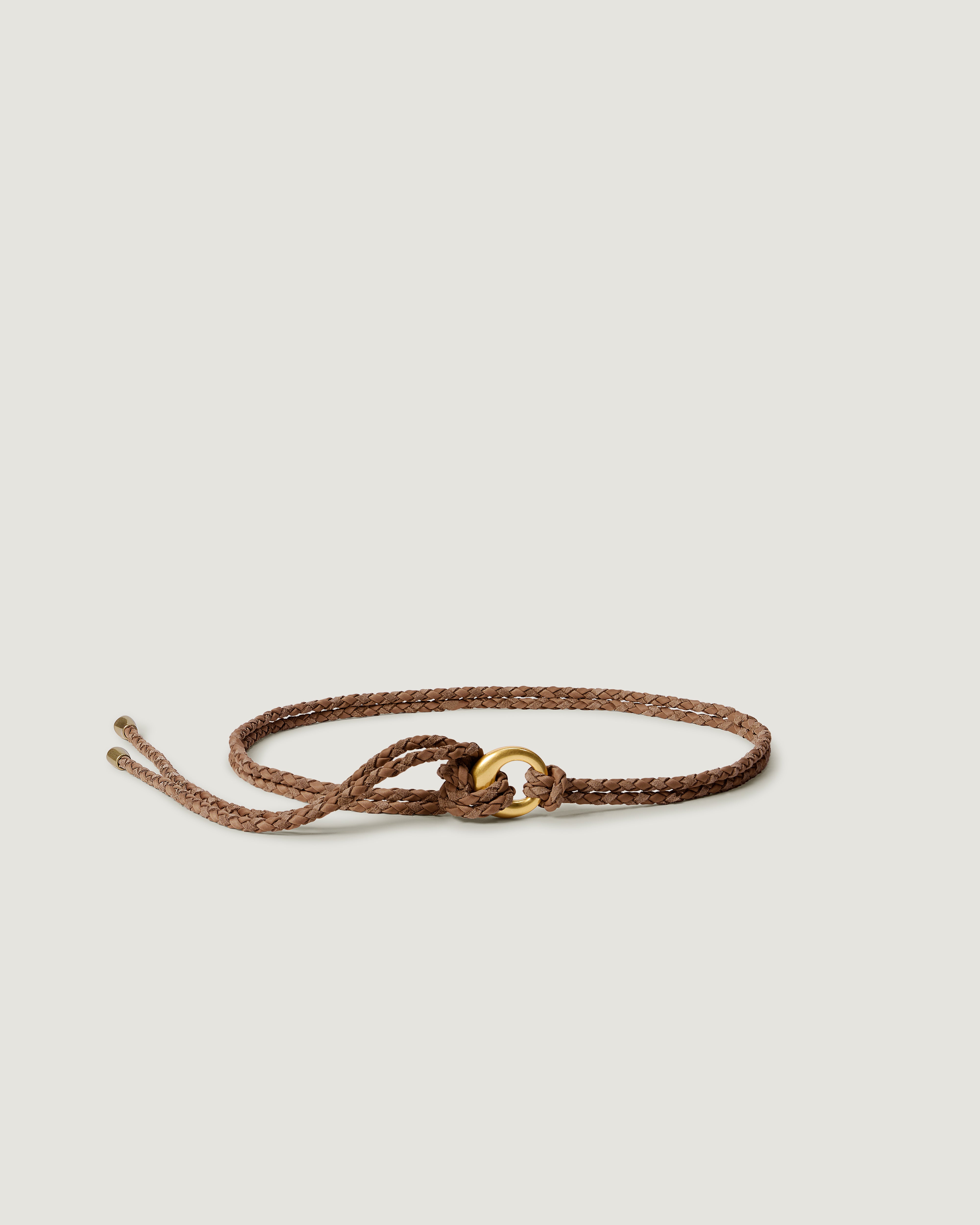 A handwoven neoprene and suede braided belt in light brown with a gold circle loop closure