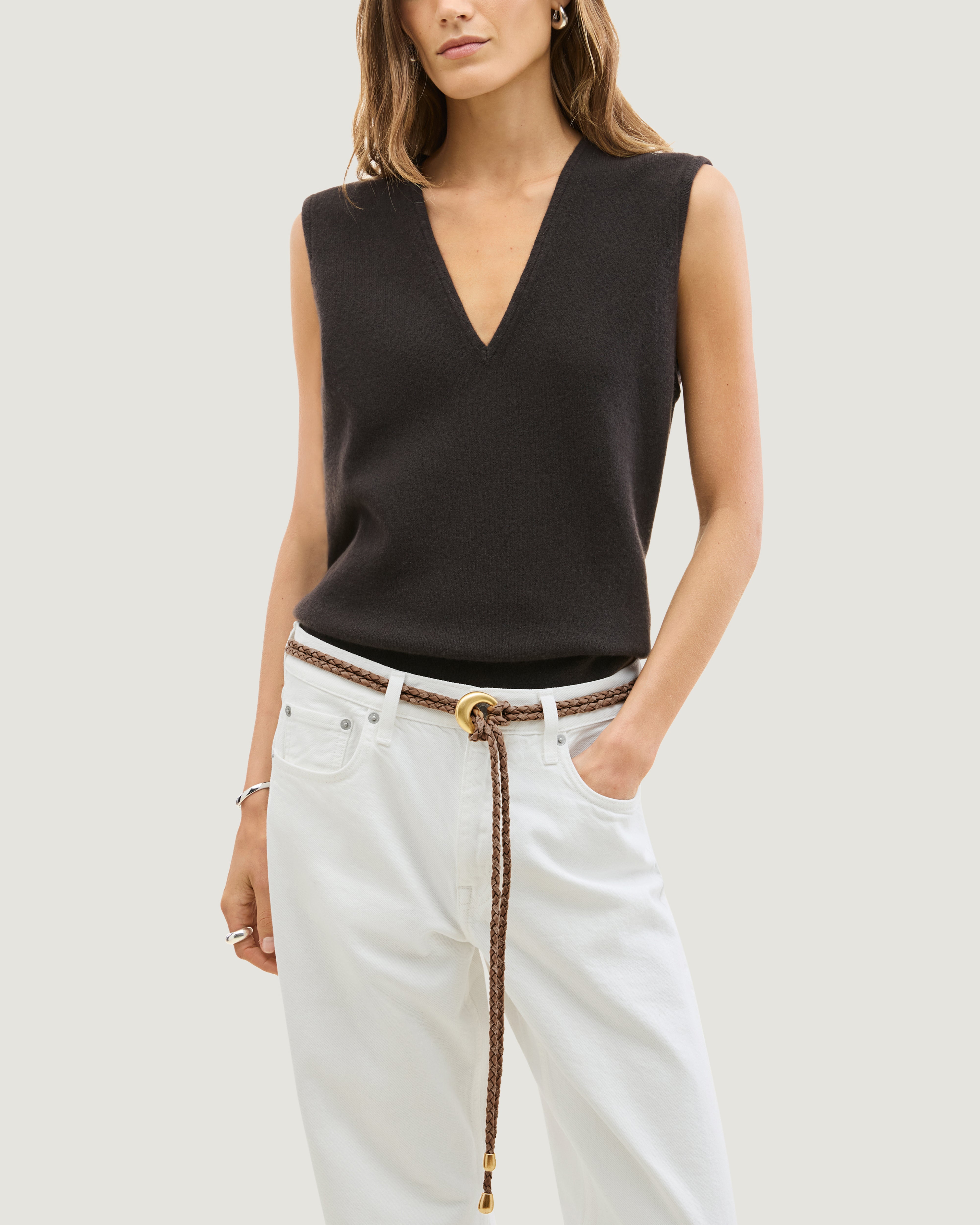Model wearing a light brown handwoven neoprene and suede braided rope belt with a gold metal ring closure and matching gold-toned tips.