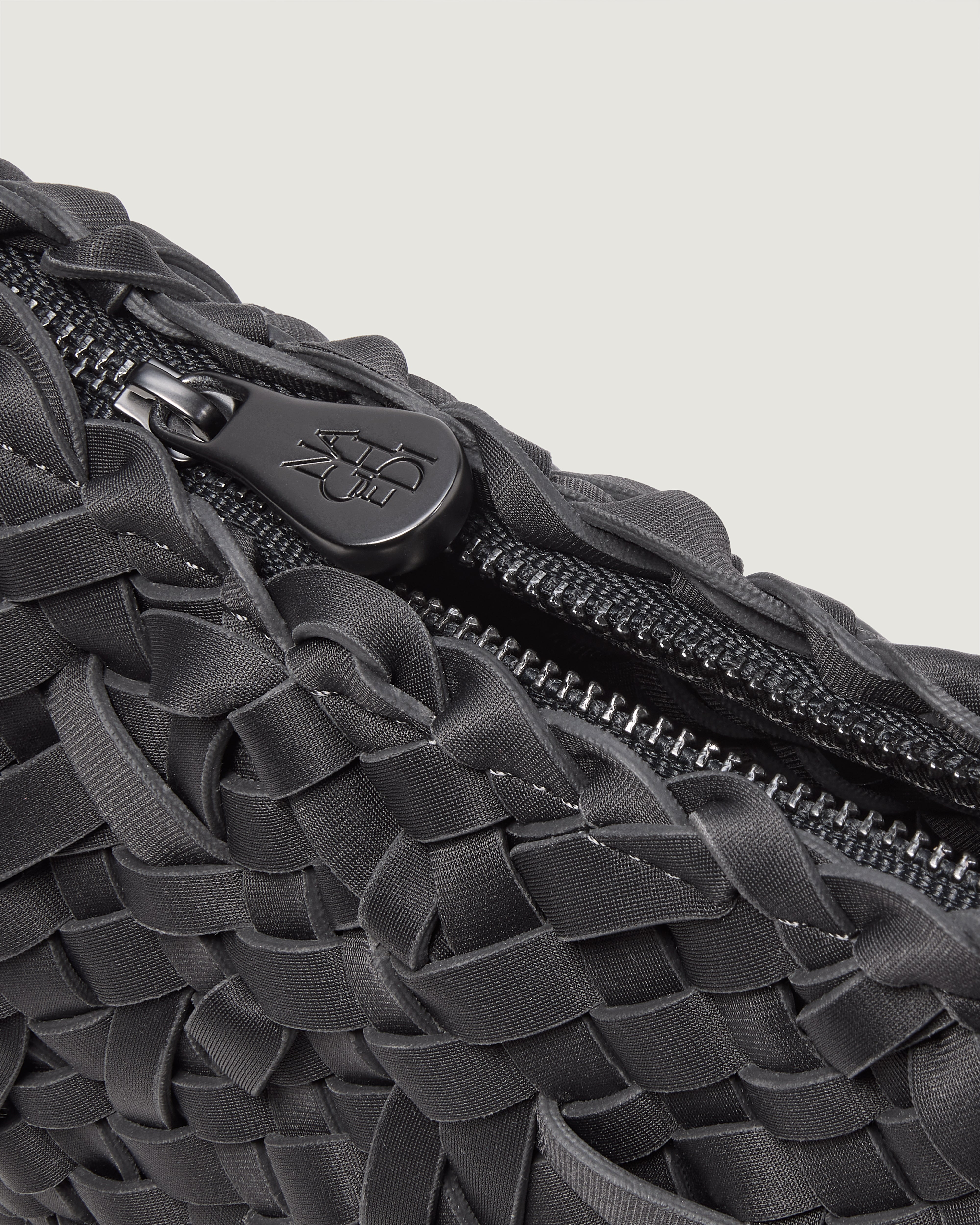 Close up of handwoven neoprene crossbody bag with black zipper in ash gray color.