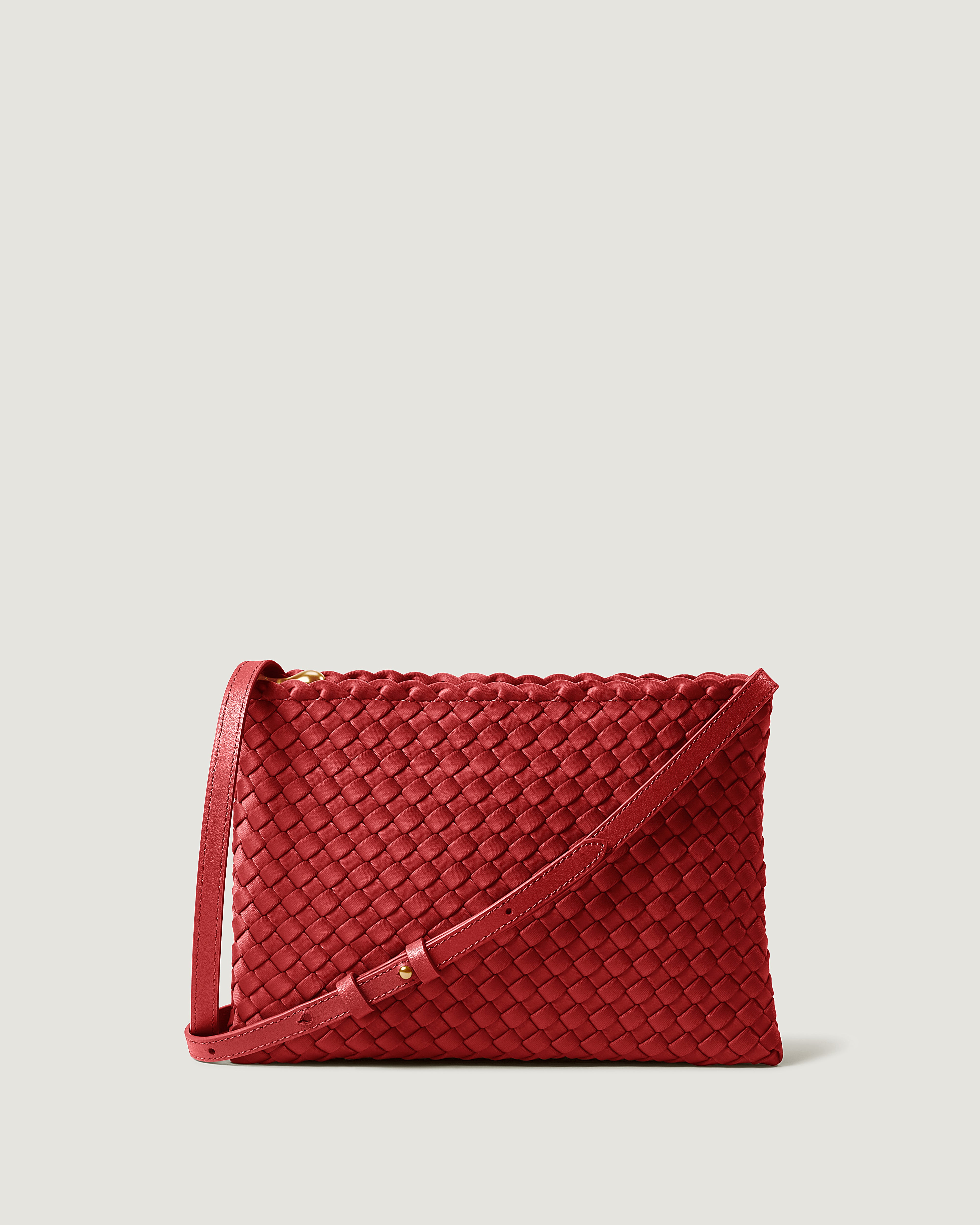 Soho Envelope in Rosso, a rich red tone, in handwoven neoprene, featuring a dual zip top closure, and adjustable leather crossbody strap.
