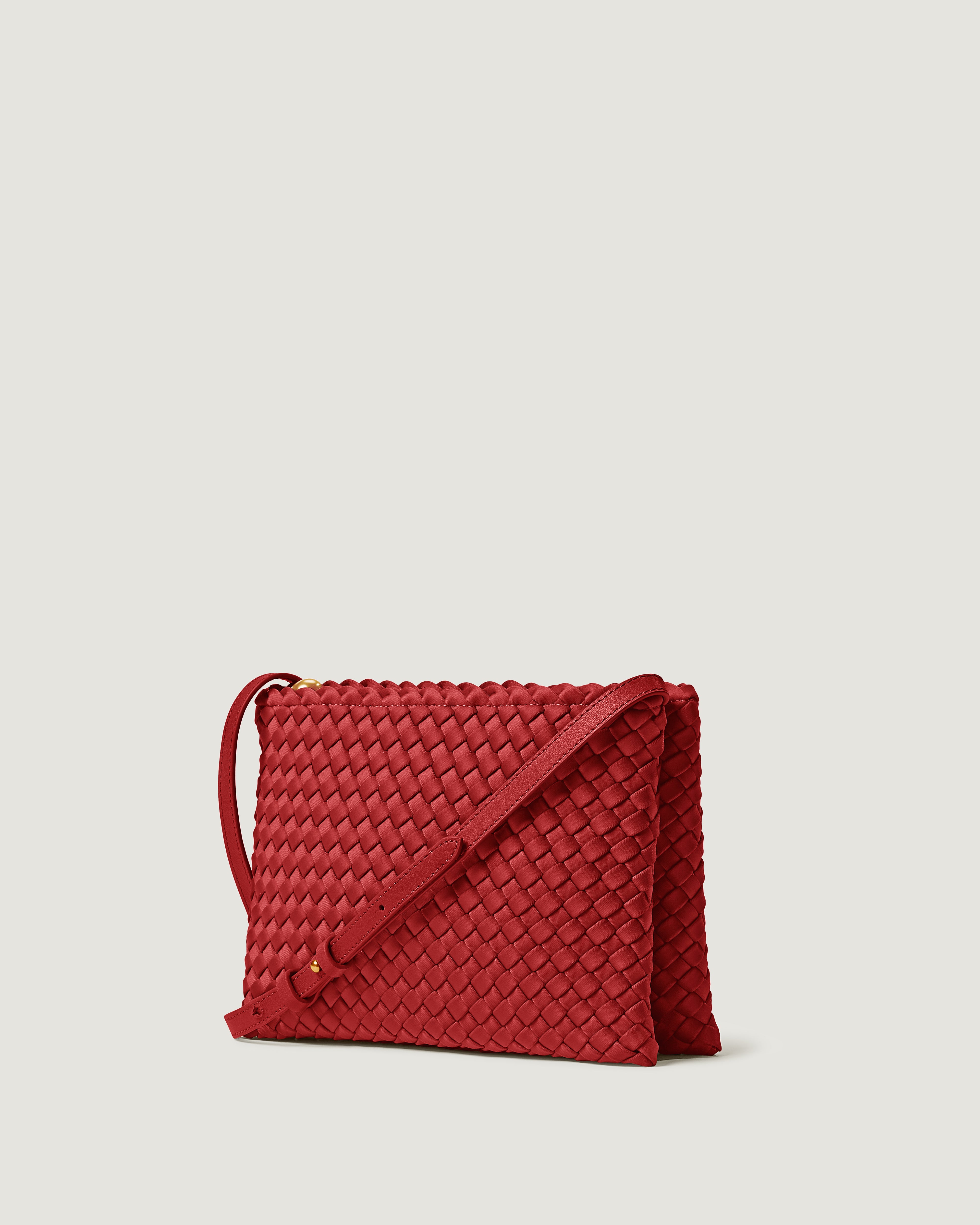 Soho Envelope in Rosso shown from a side angle, highlighting its handwoven neoprene construction and dual zip top closure.