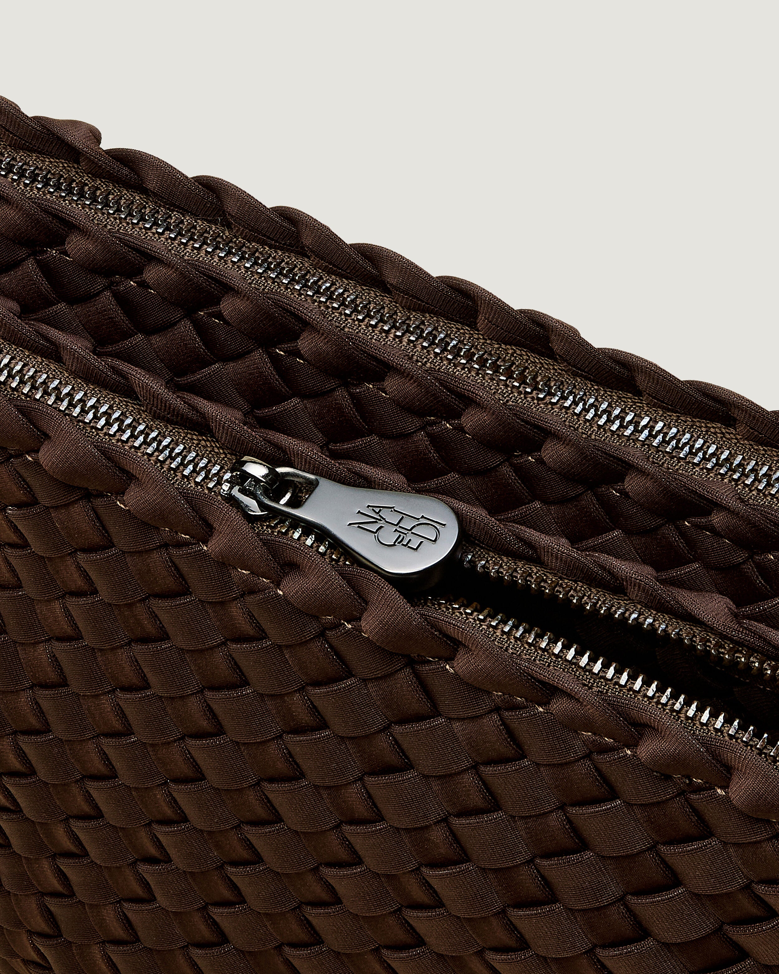 Interior close-up of Soho Envelope in Chocolate showing its dual zip top closure, and unlined interior.