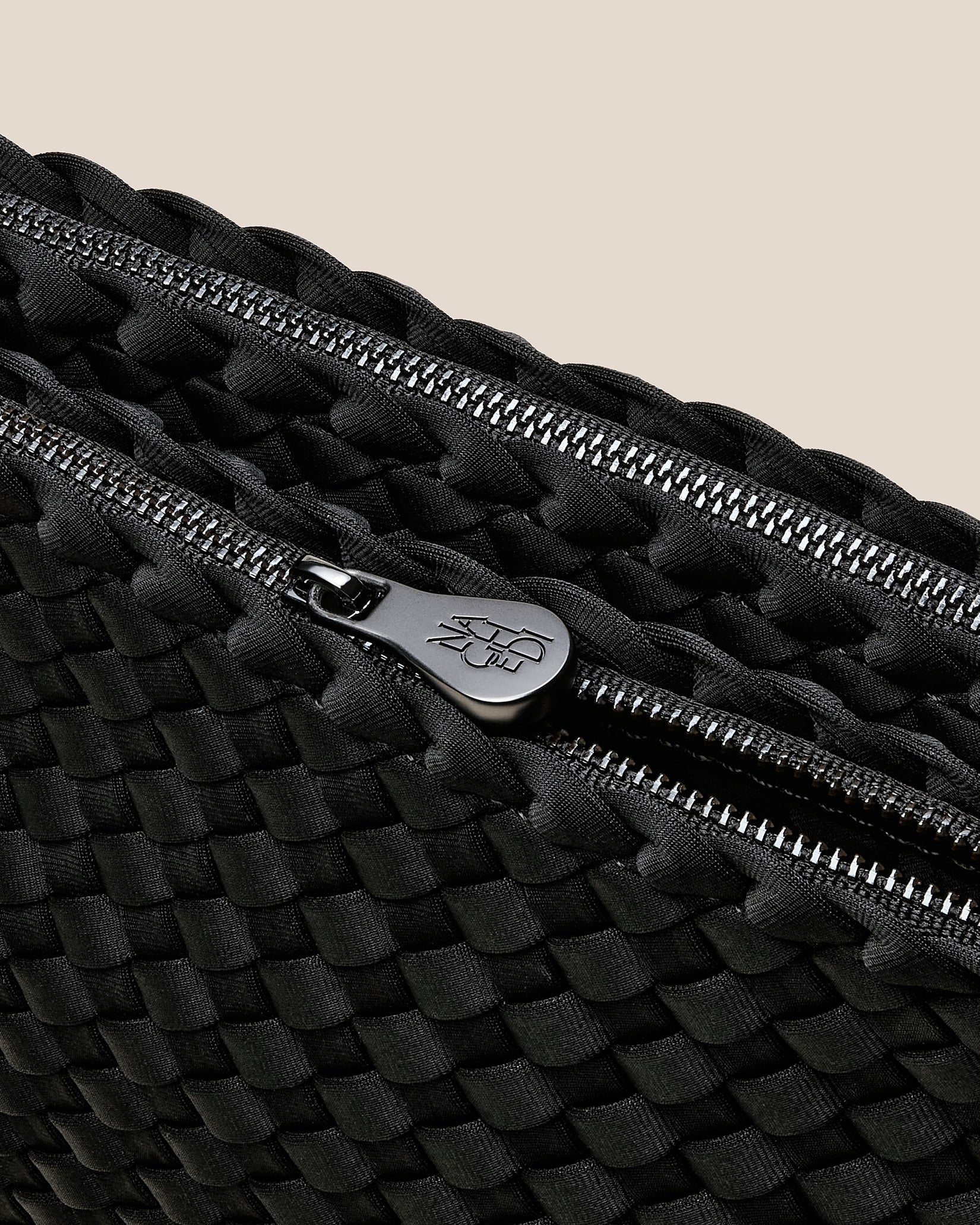 Interior close-up of Soho Medium Envelope Crossbody in Onyx showing its dual zip top closure, and unlined interior.