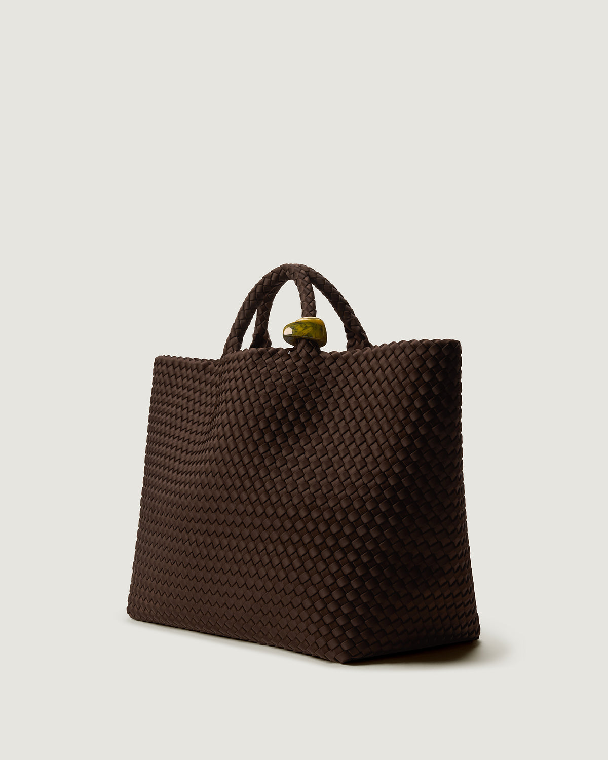 St. Barths Tote in Chocolate shown from a side angle, highlighting its handwoven neoprene construction and open top.
