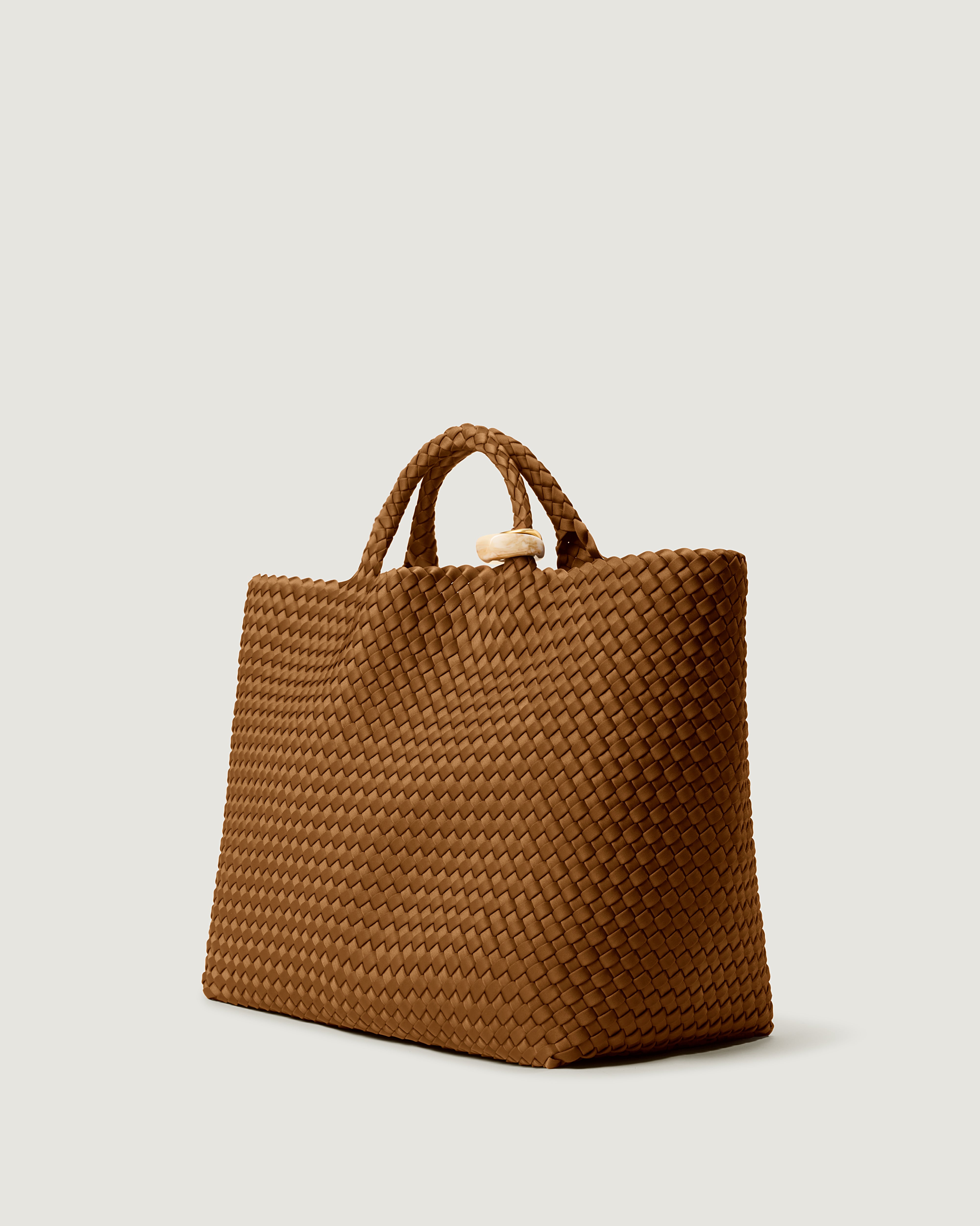 St. Barths Tote in Teak shown from a side angle, highlighting its handwoven neoprene construction and open top.