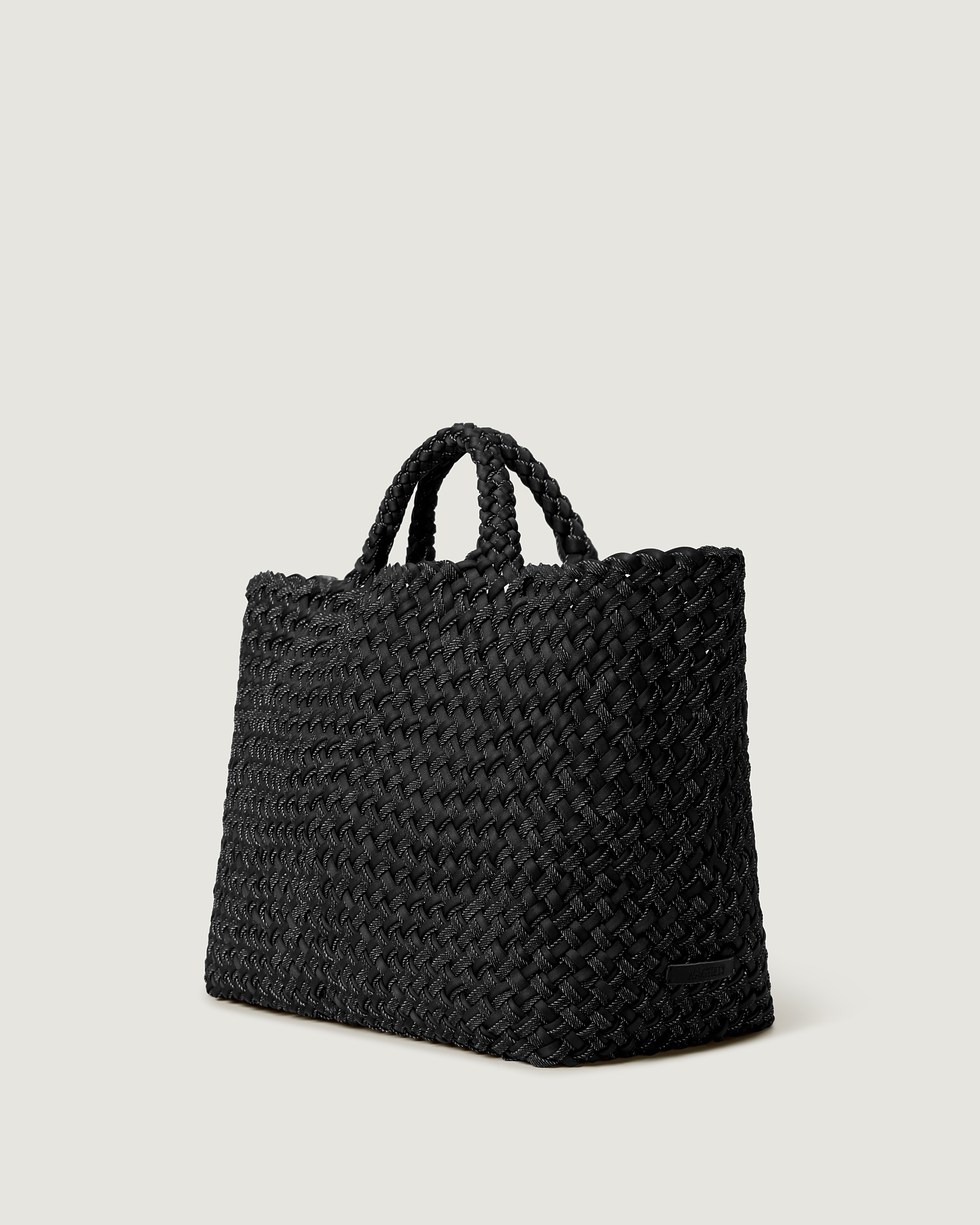 St. Barths Tote in Jet shown from a side angle, highlighting its handwoven denim construction and open top.