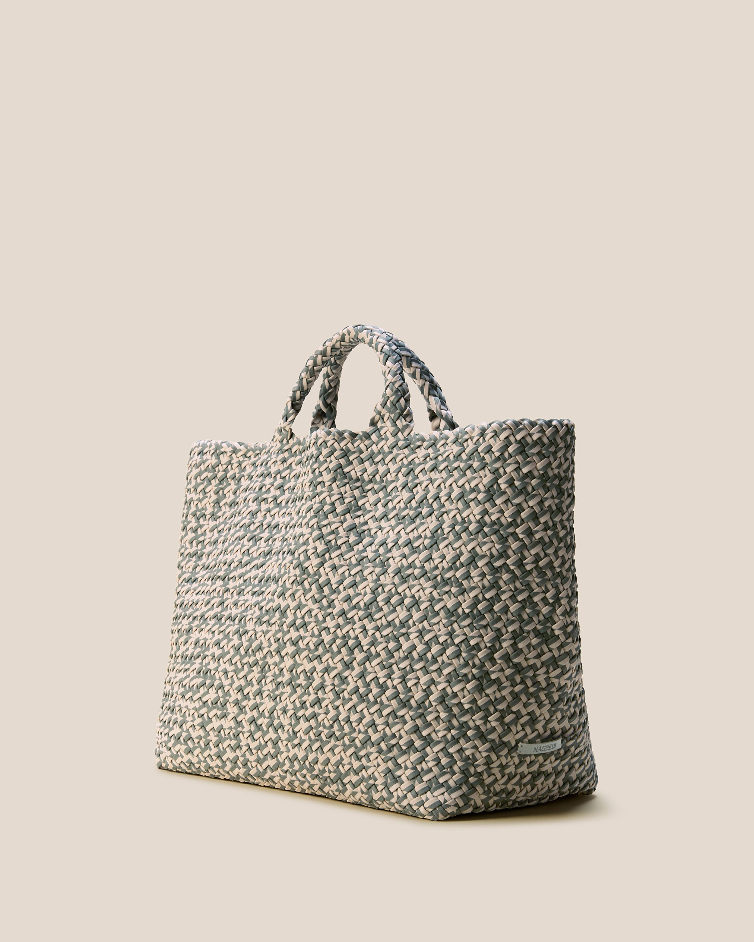 St. Barths Tote in Papyrus shown from a side angle, highlighting its handwoven neoprene construction and open top.