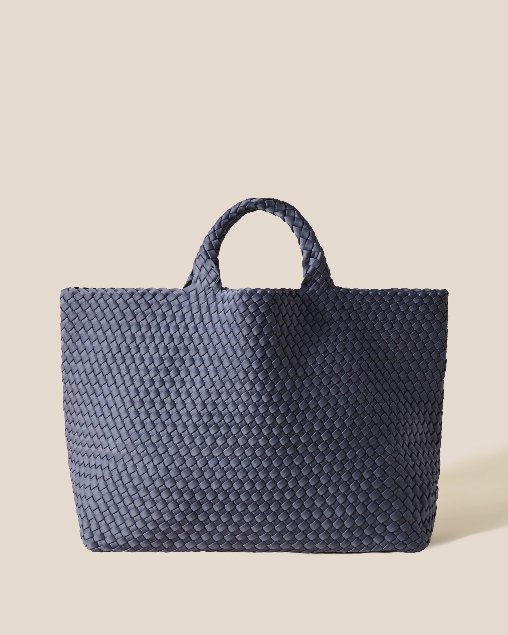 St. Barths Tote in Anchor, a muted blue gray tone, in handwoven neoprene, featuring an open top, and woven top handles.