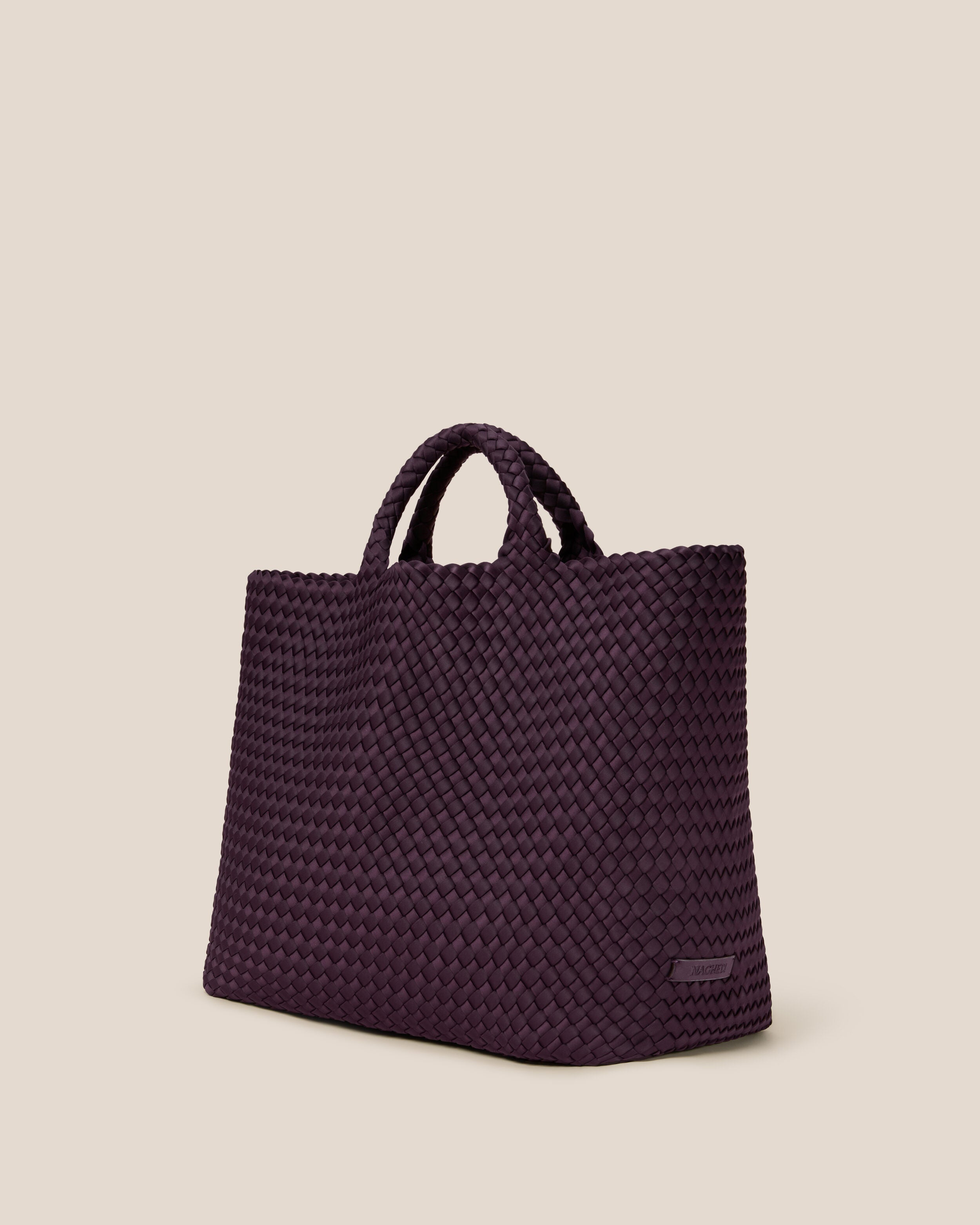 St. Barths Tote in Aubergine shown from a side angle, highlighting its handwoven neoprene construction and open top.