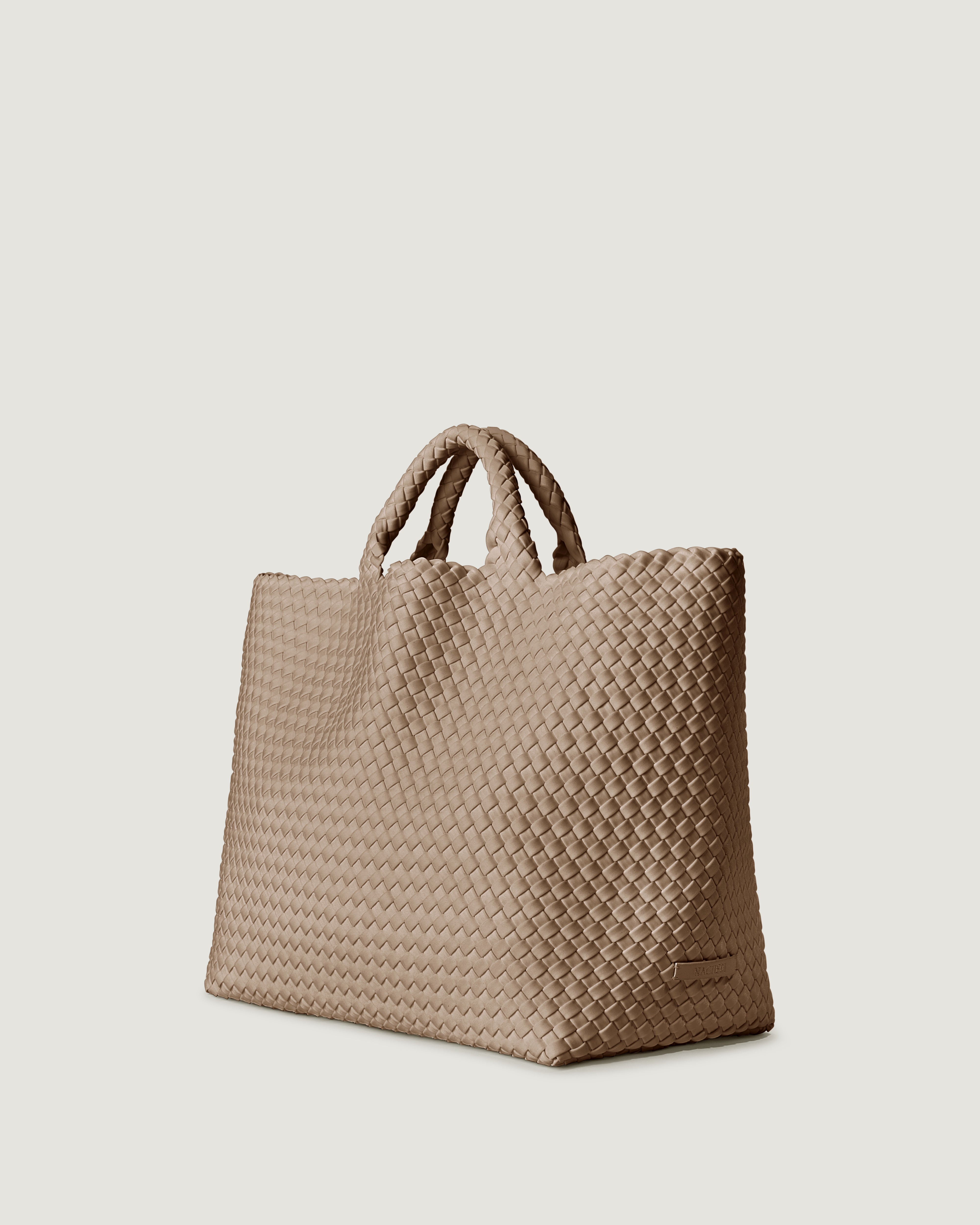 St. Barths Tote in Cashmere shown from a side angle, highlighting its handwoven neoprene construction and open top.