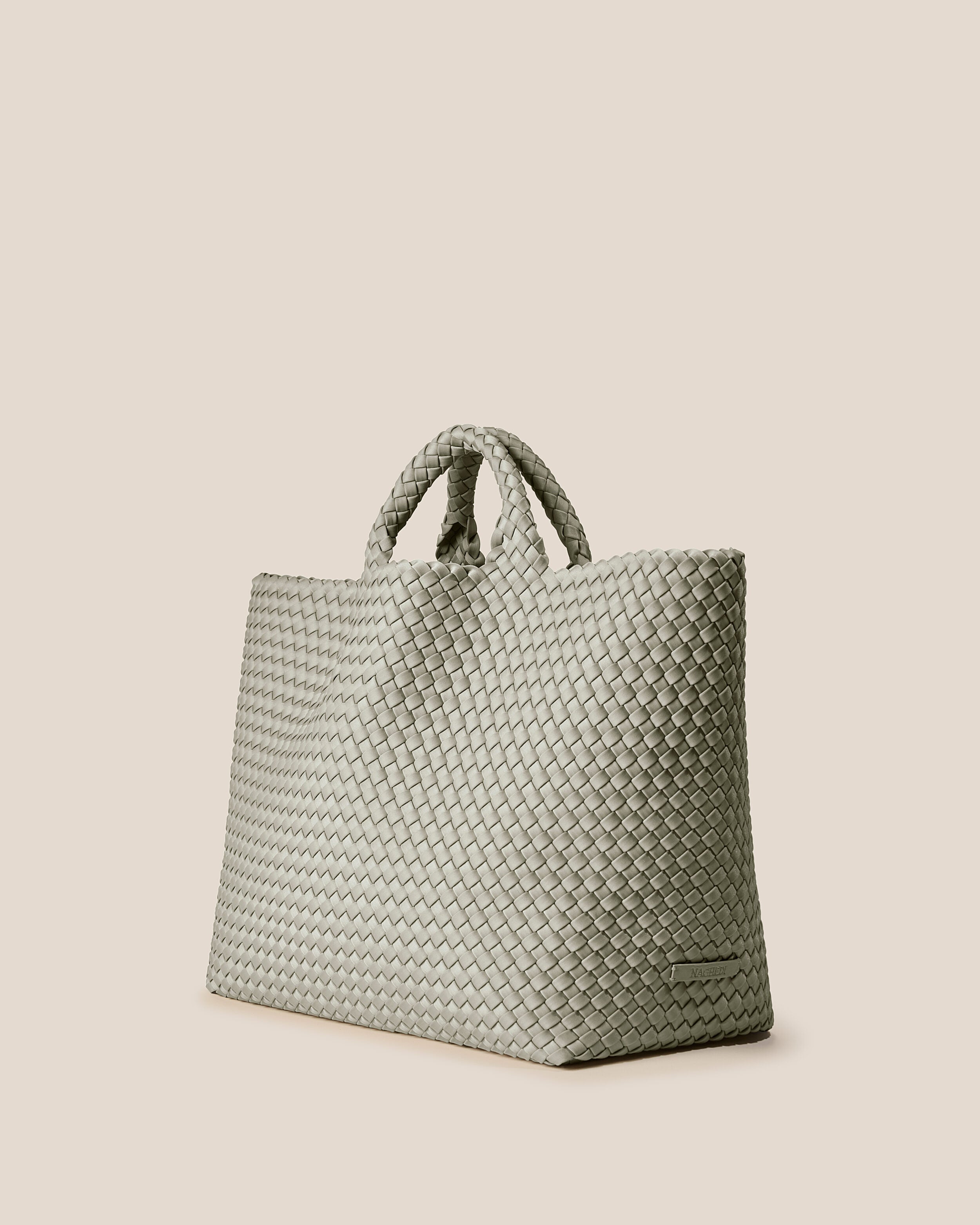 St. Barths Tote in Celadon shown from a side angle, highlighting its handwoven neoprene construction and open top.