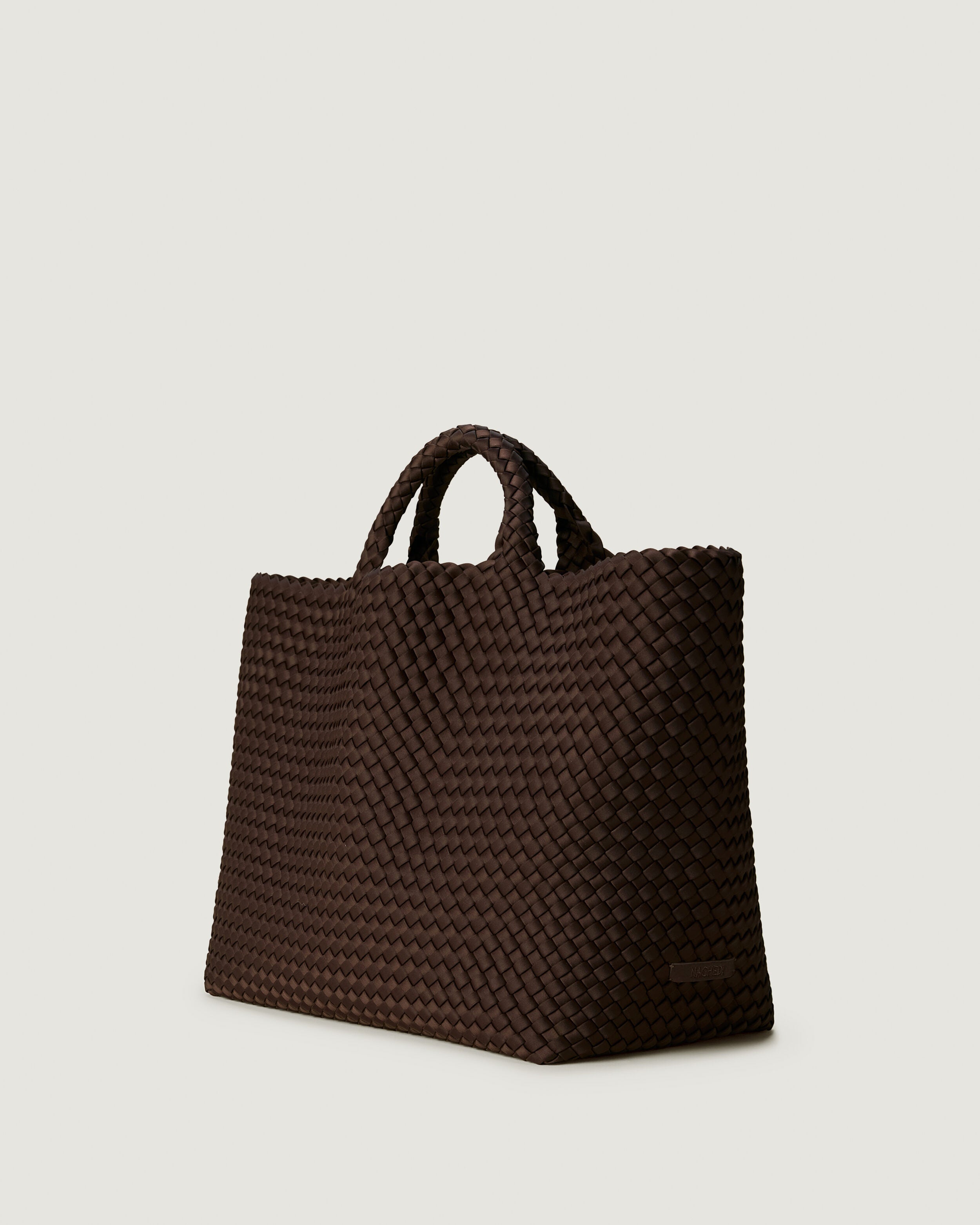 St. Barths Tote in Chocolate shown from a side angle, highlighting its handwoven neoprene construction and open top.