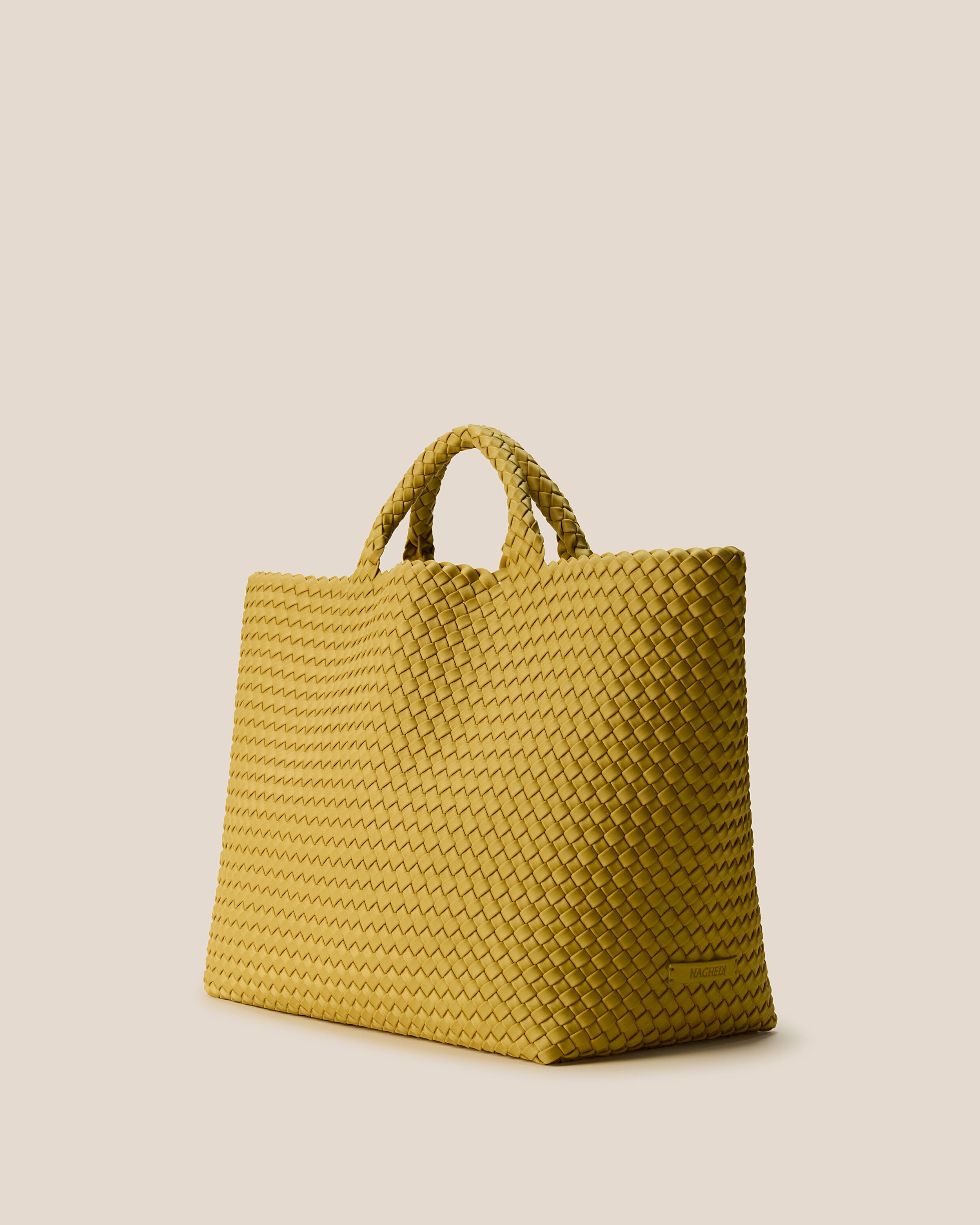 St. Barths Tote in Citrine shown from a side angle, highlighting its handwoven neoprene construction and open top.
