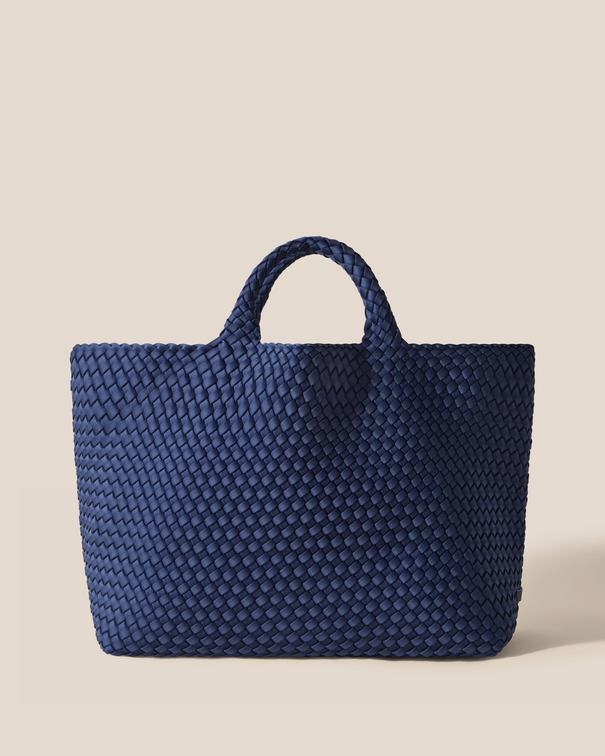 St. Barths Tote in Ink Blue, a navy blue tone, in handwoven neoprene, featuring an open top, and woven top handles.