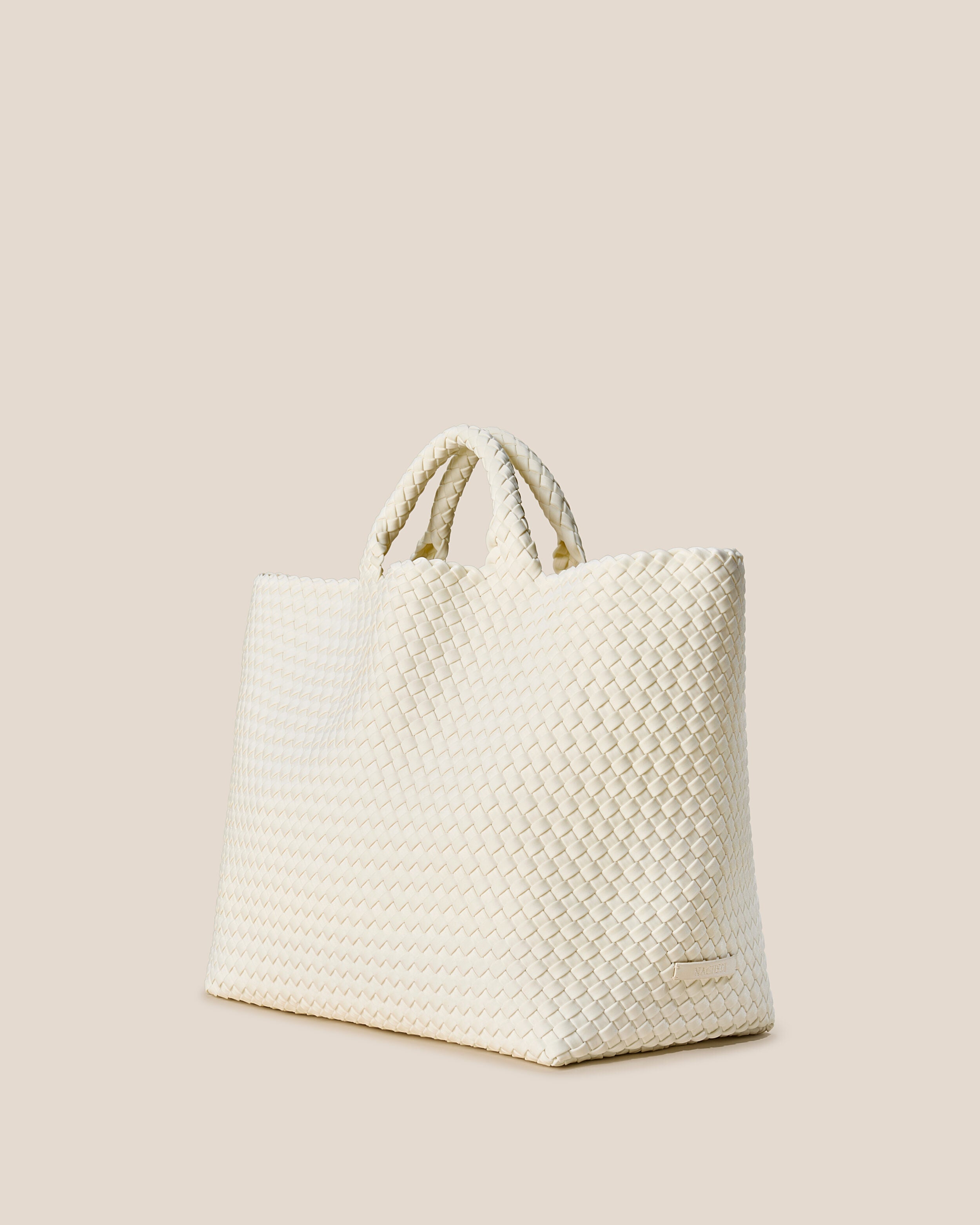 St. Barths Tote in Jasmine shown from a side angle, highlighting its handwoven neoprene construction and open top.