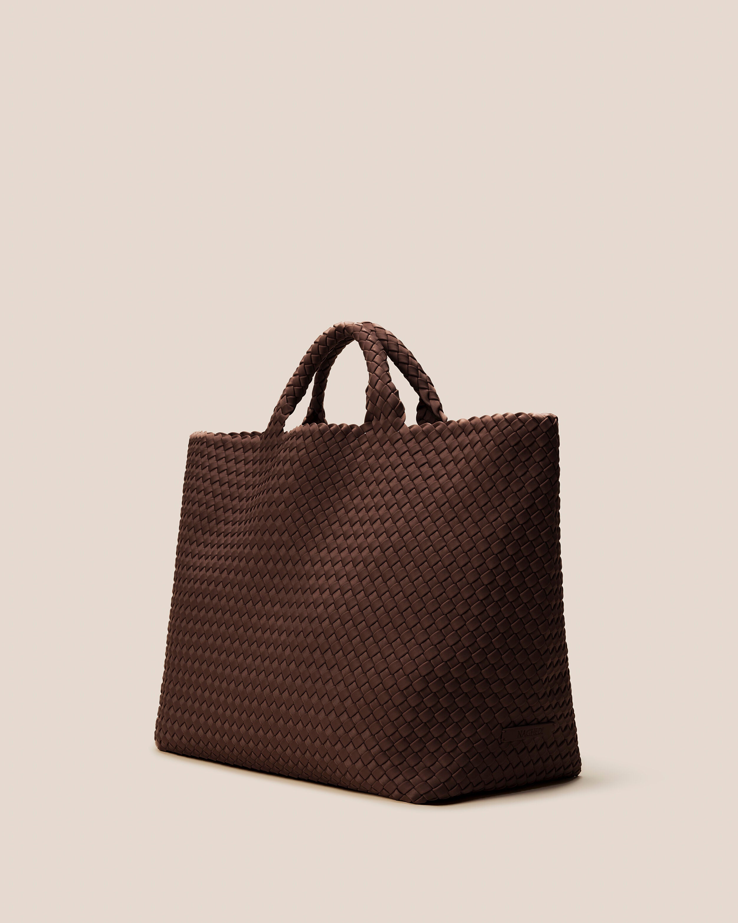 St. Barths Tote in Mocha shown from a side angle, highlighting its handwoven neoprene construction and open top.