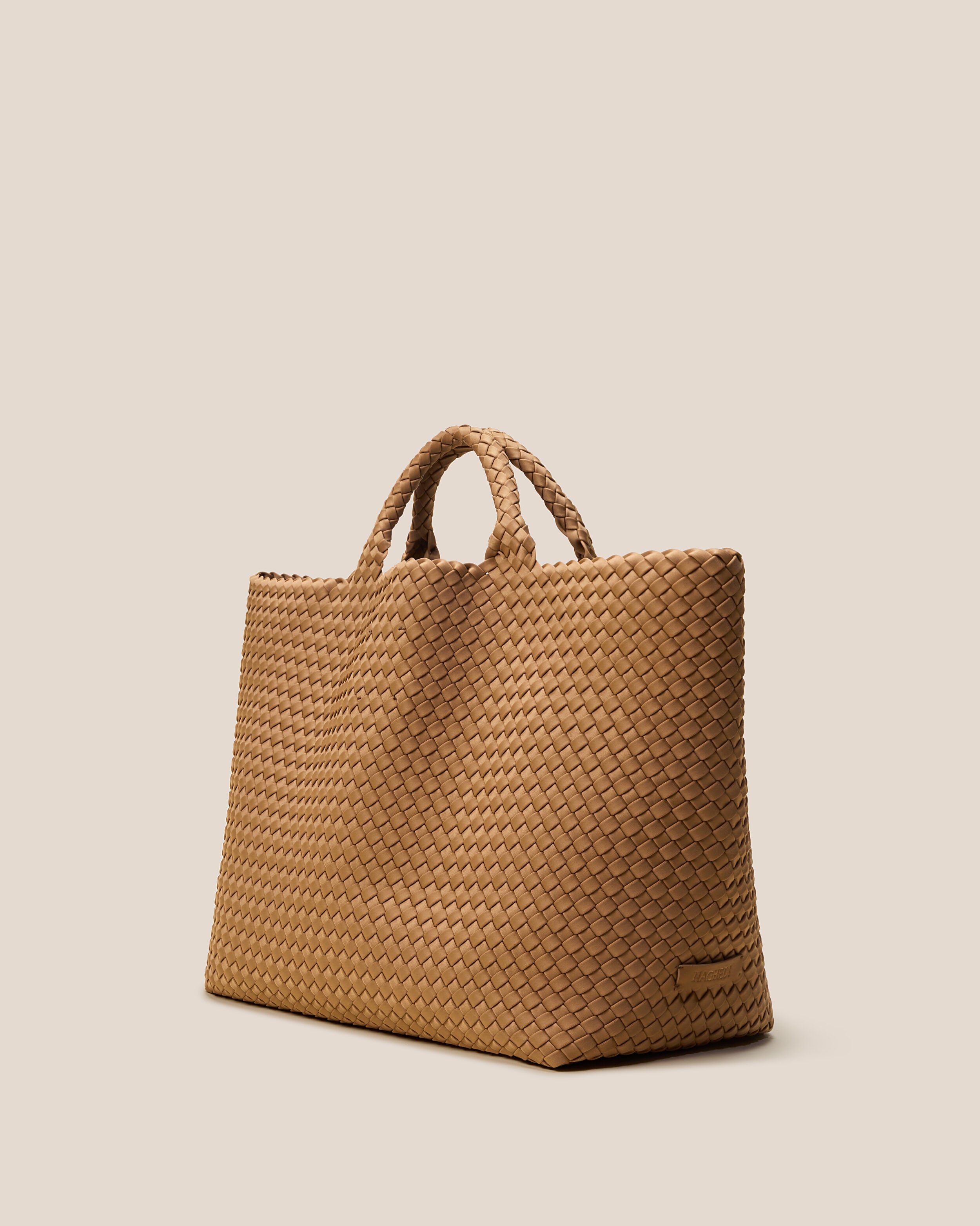St. Barths Tote in Montauk shown from a side angle, highlighting its handwoven neoprene construction and open top.