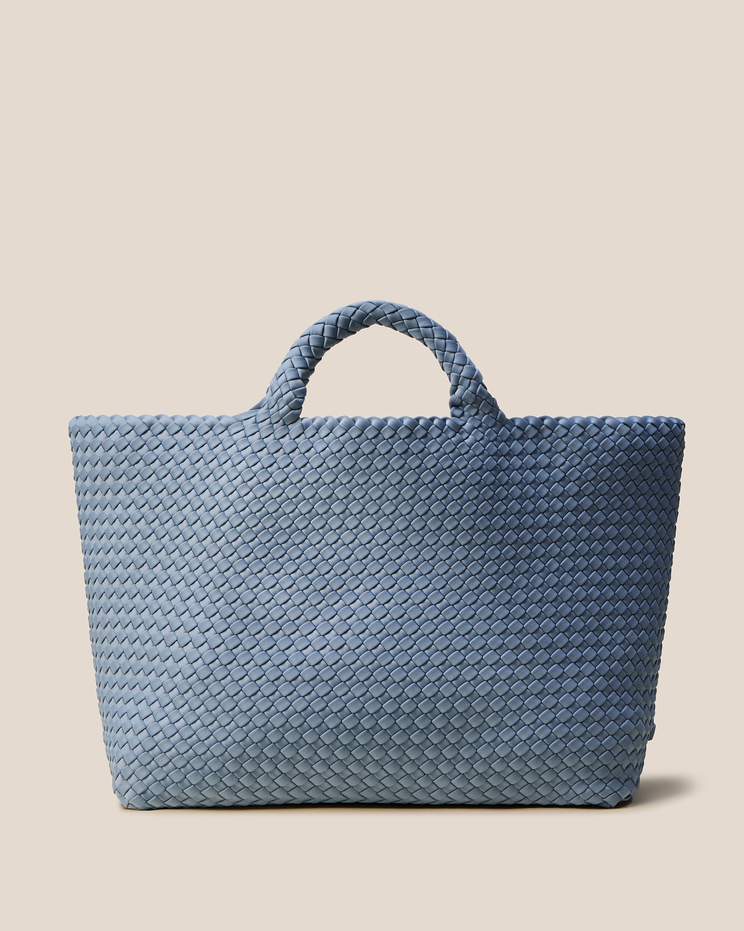 St. Barths Tote in Nova, a muted denim blue tone, in handwoven neoprene, featuring an open top, and woven top handles.