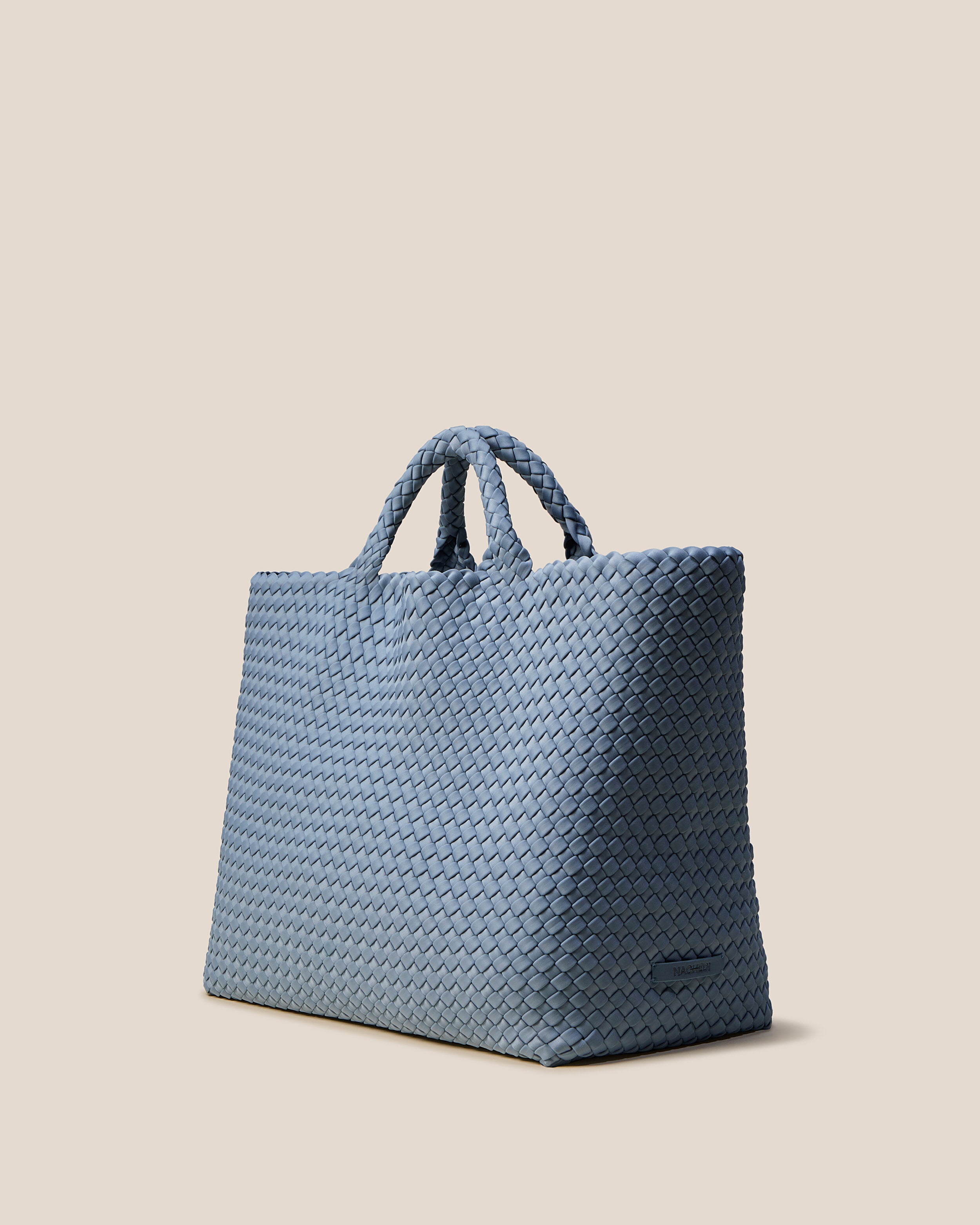 St. Barths Tote in Nova shown from a side angle, highlighting its handwoven neoprene construction and open top.