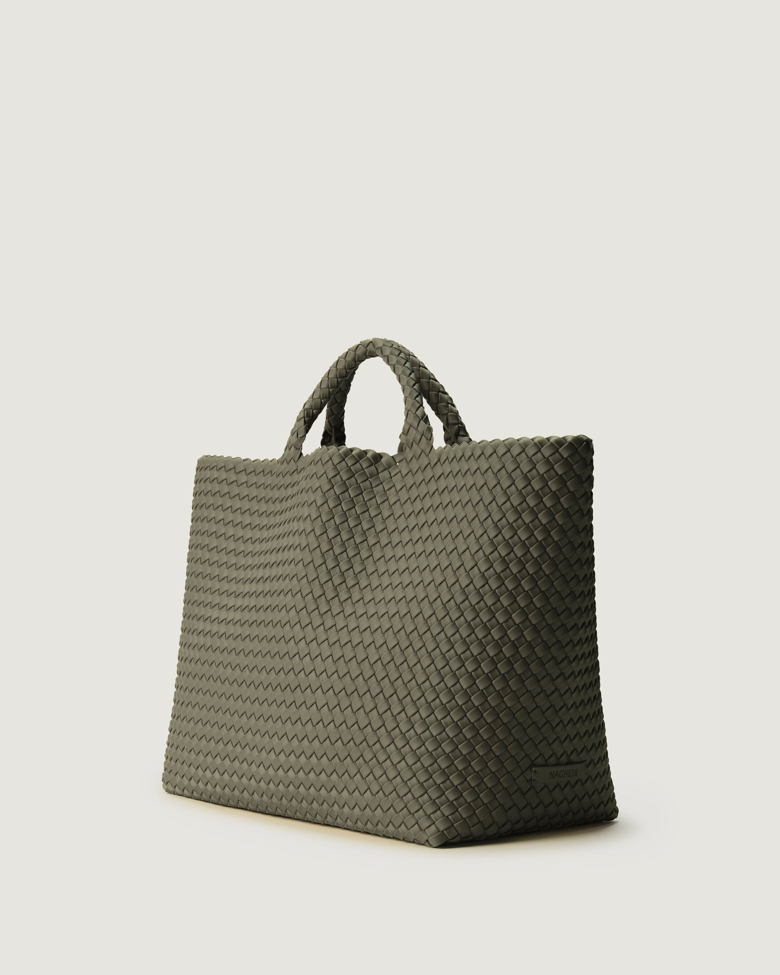 St. Barths Tote in Olea shown from a side angle, highlighting its handwoven neoprene construction and open top.