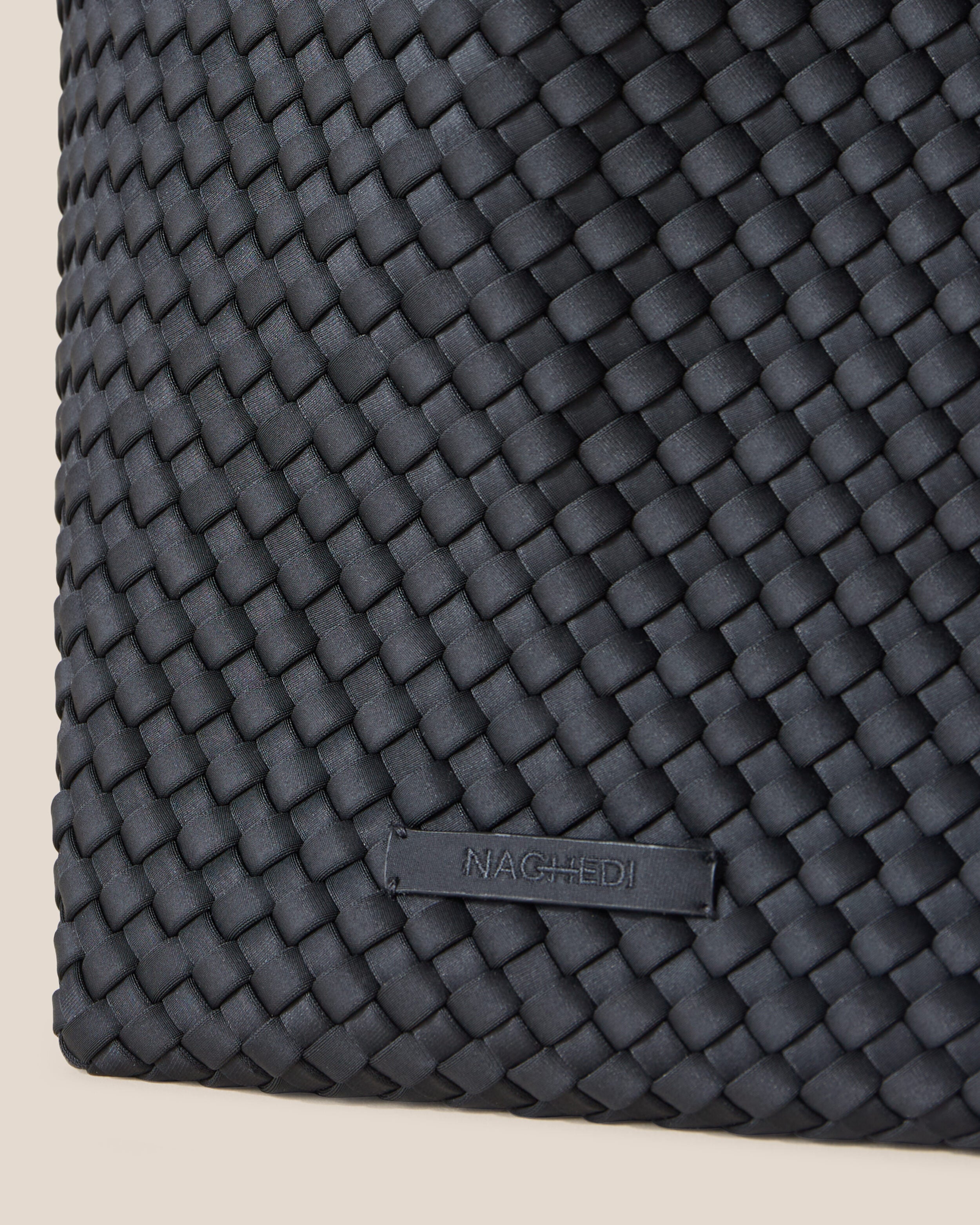 Close-up of stamped NAGHEDI logo on St. Barths Tote in Onyx.