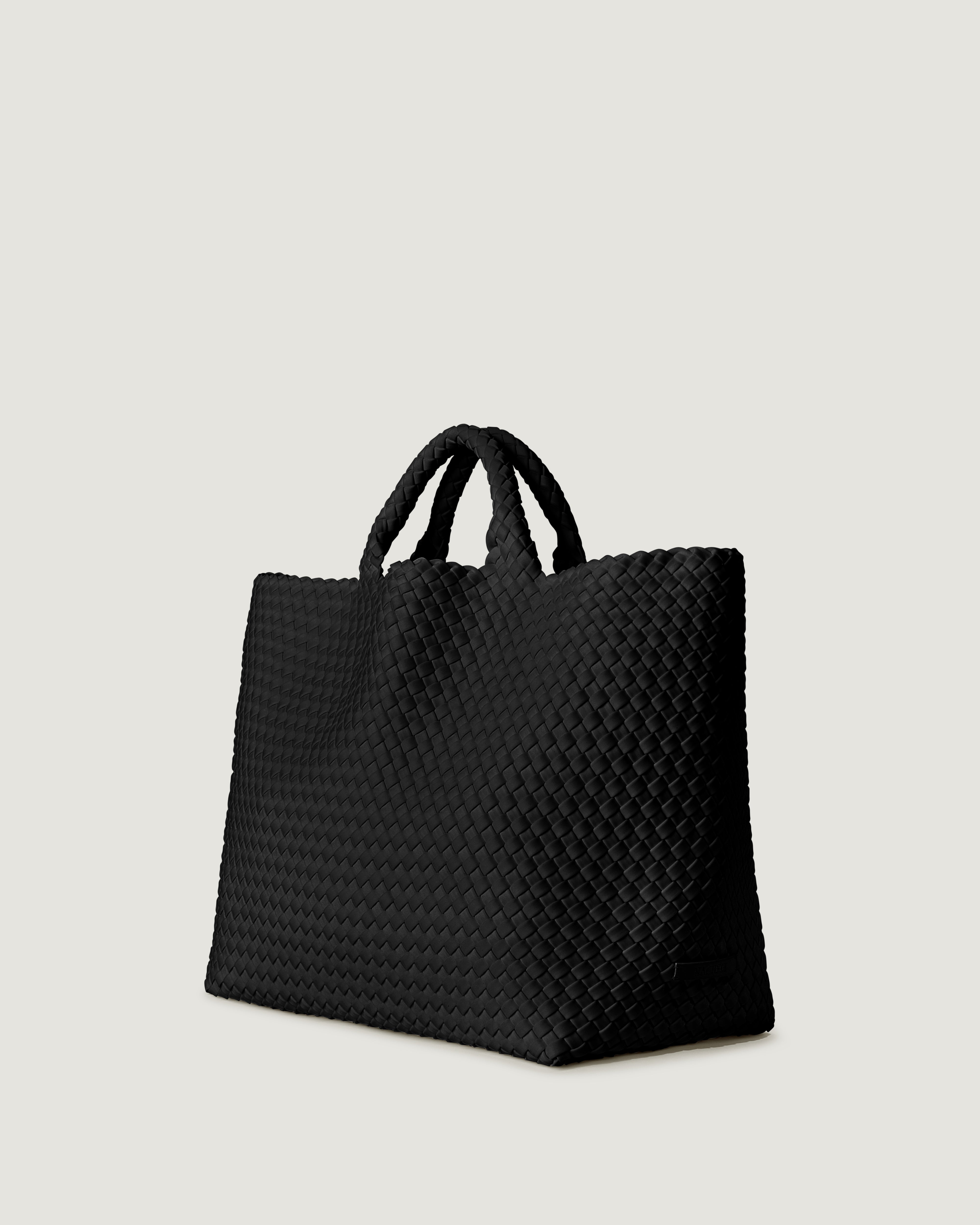 St. Barths Tote in Chocolate shown from a side angle, highlighting its handwoven neoprene construction and open top.