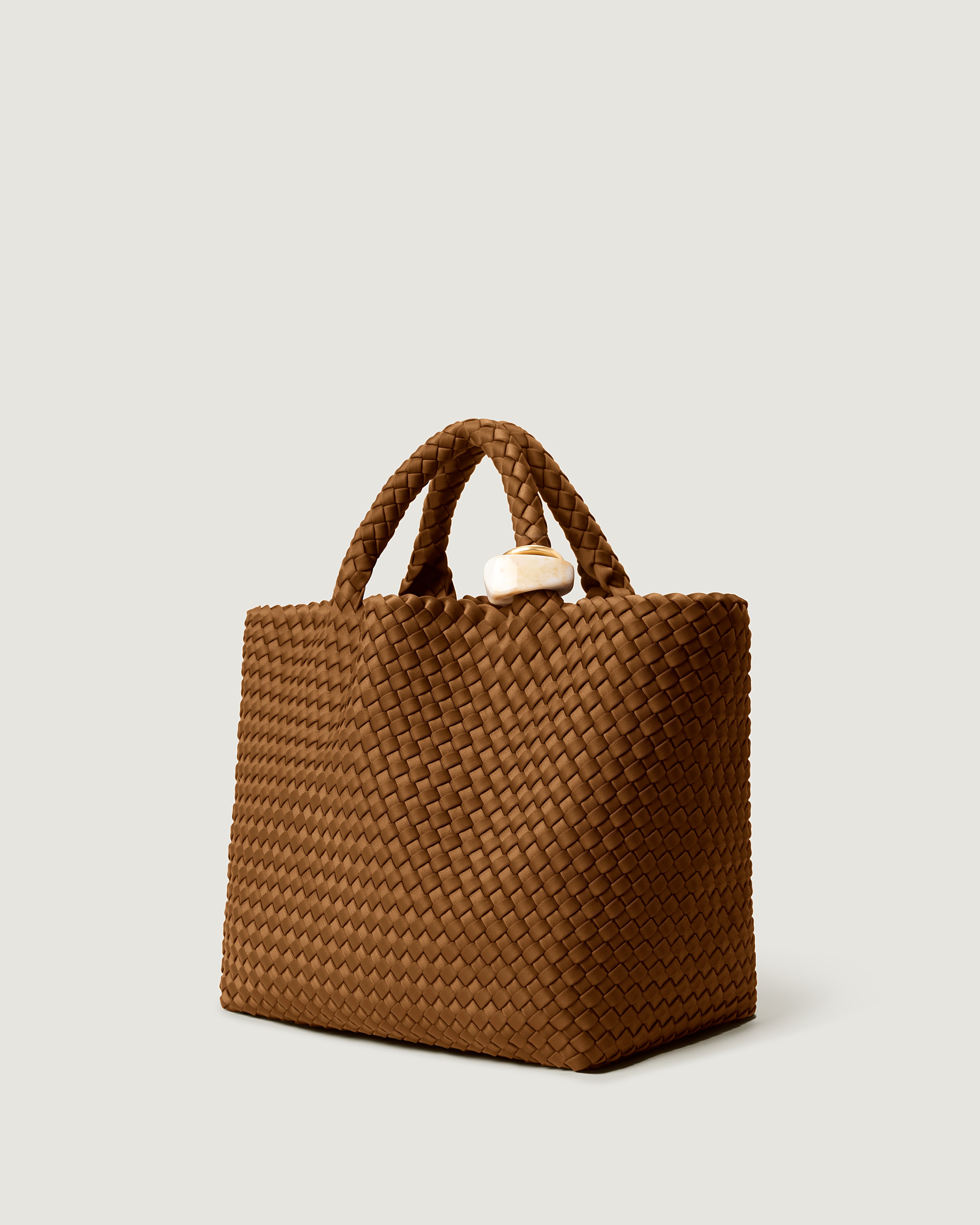 St. Barths Tote in Teak shown from a side angle, highlighting its handwoven neoprene construction and open top.