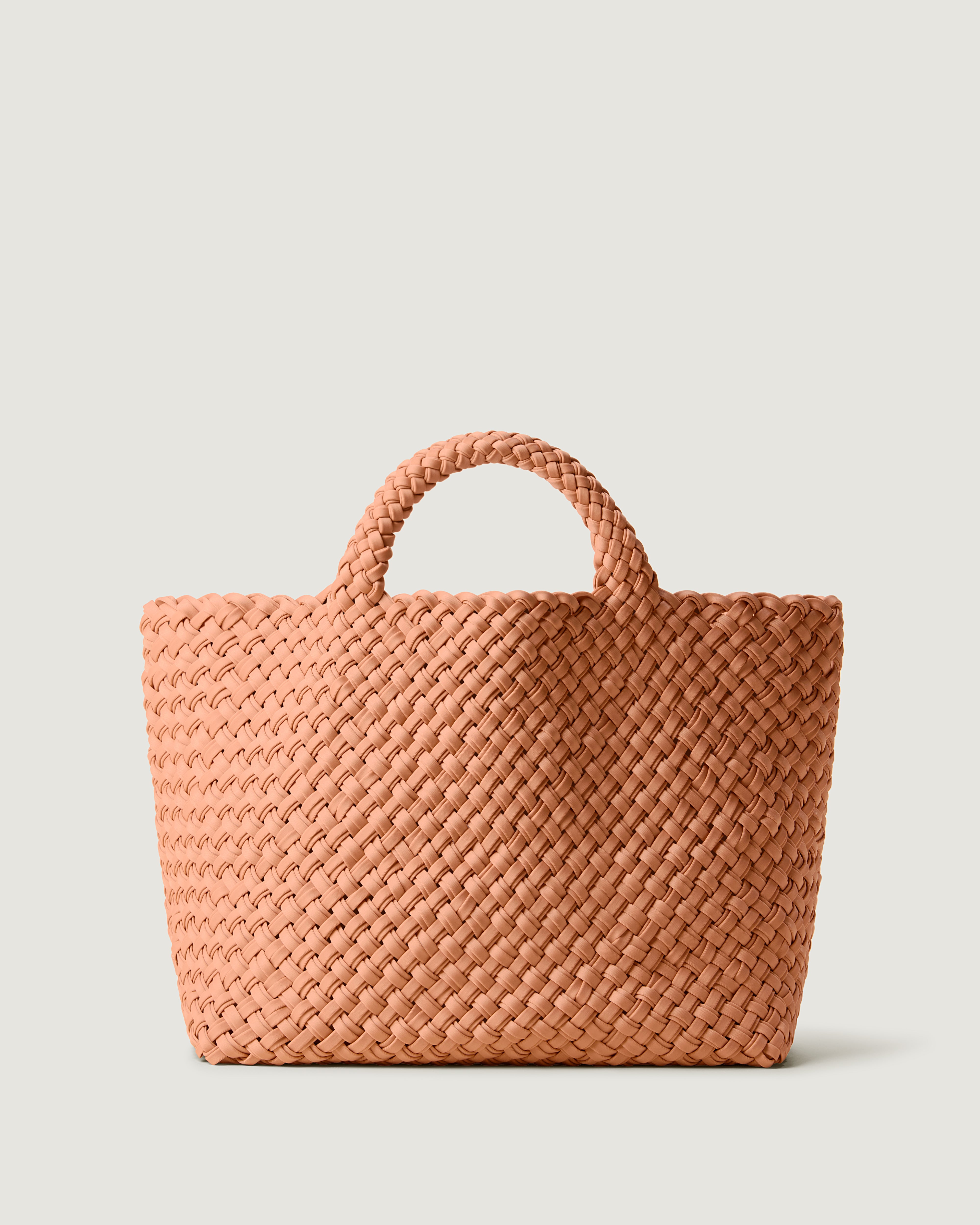 St. Barths Tote in Etna, handwoven from doubled strands of muted coral neoprene. Featuring an open top and woven handles.