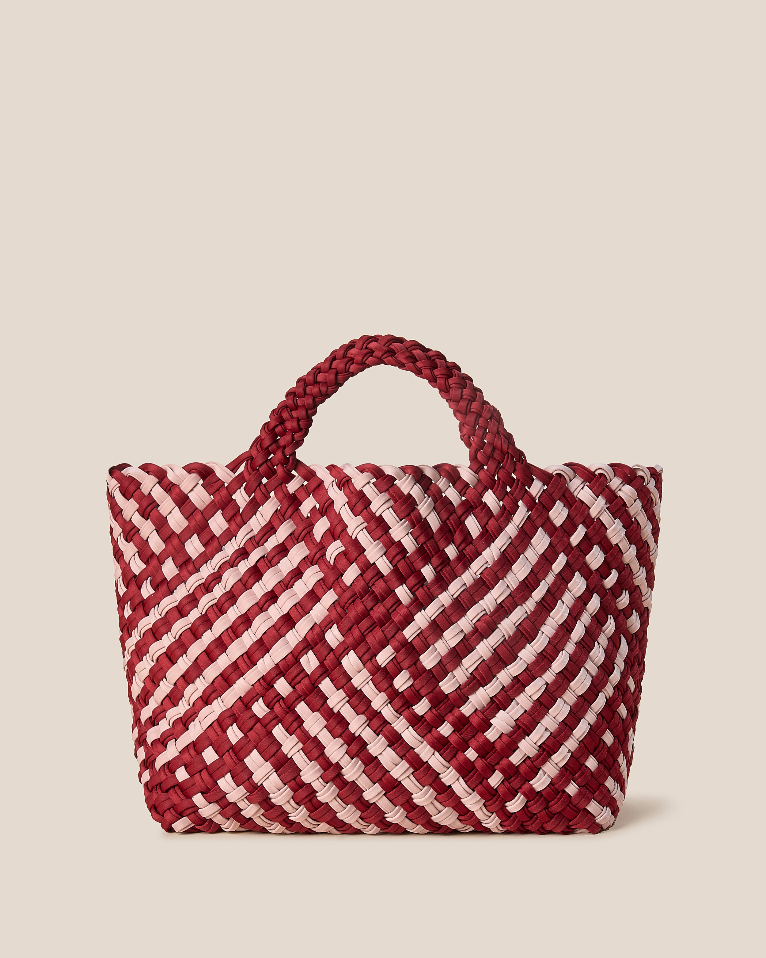 St. Barths Tote in Lychee, a rich red and soft ballet pink tone, in handwoven neoprene, featuring an open top, and woven top handles.