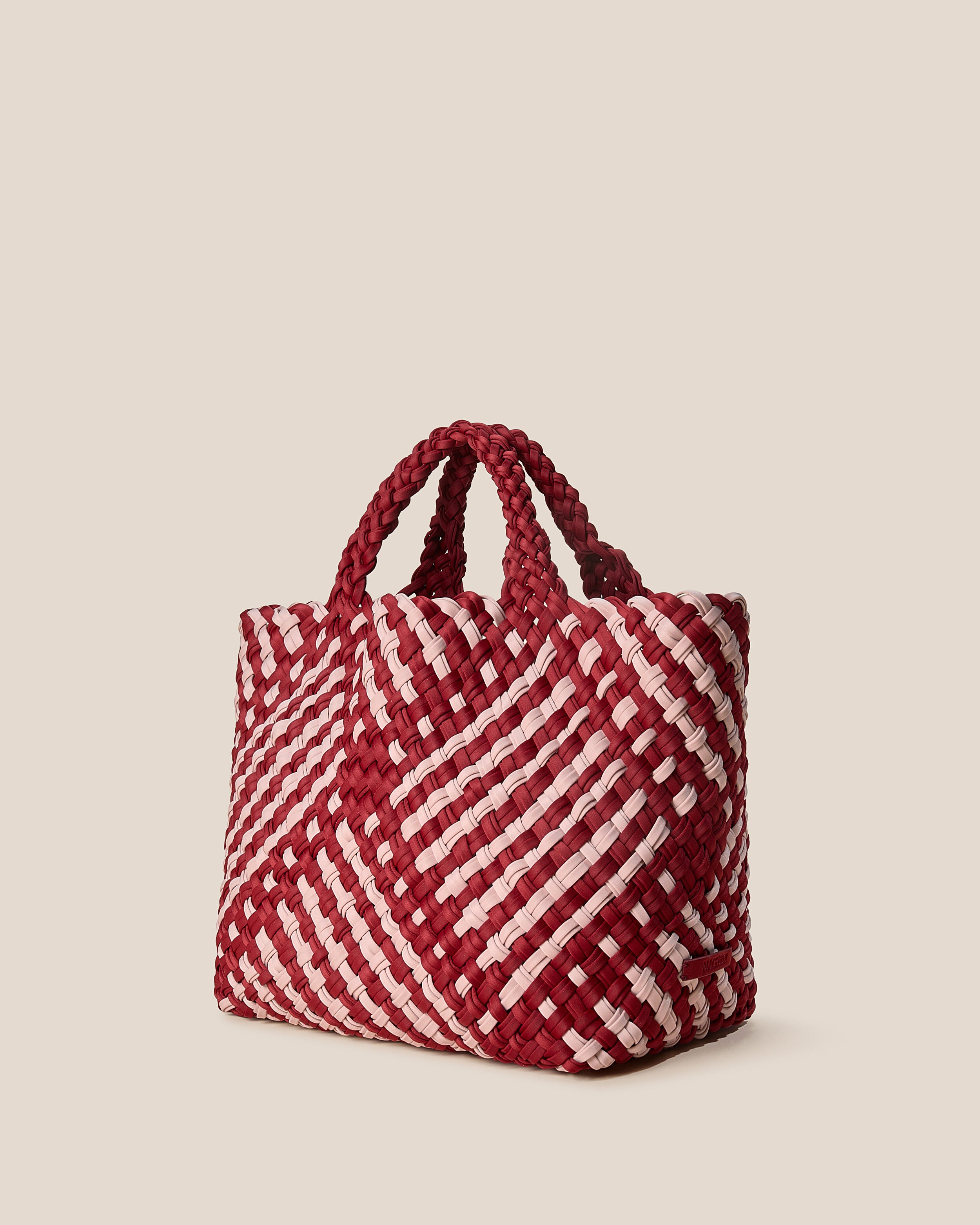 St. Barths Tote in Lychee shown from a side angle, highlighting its handwoven neoprene construction and open top.