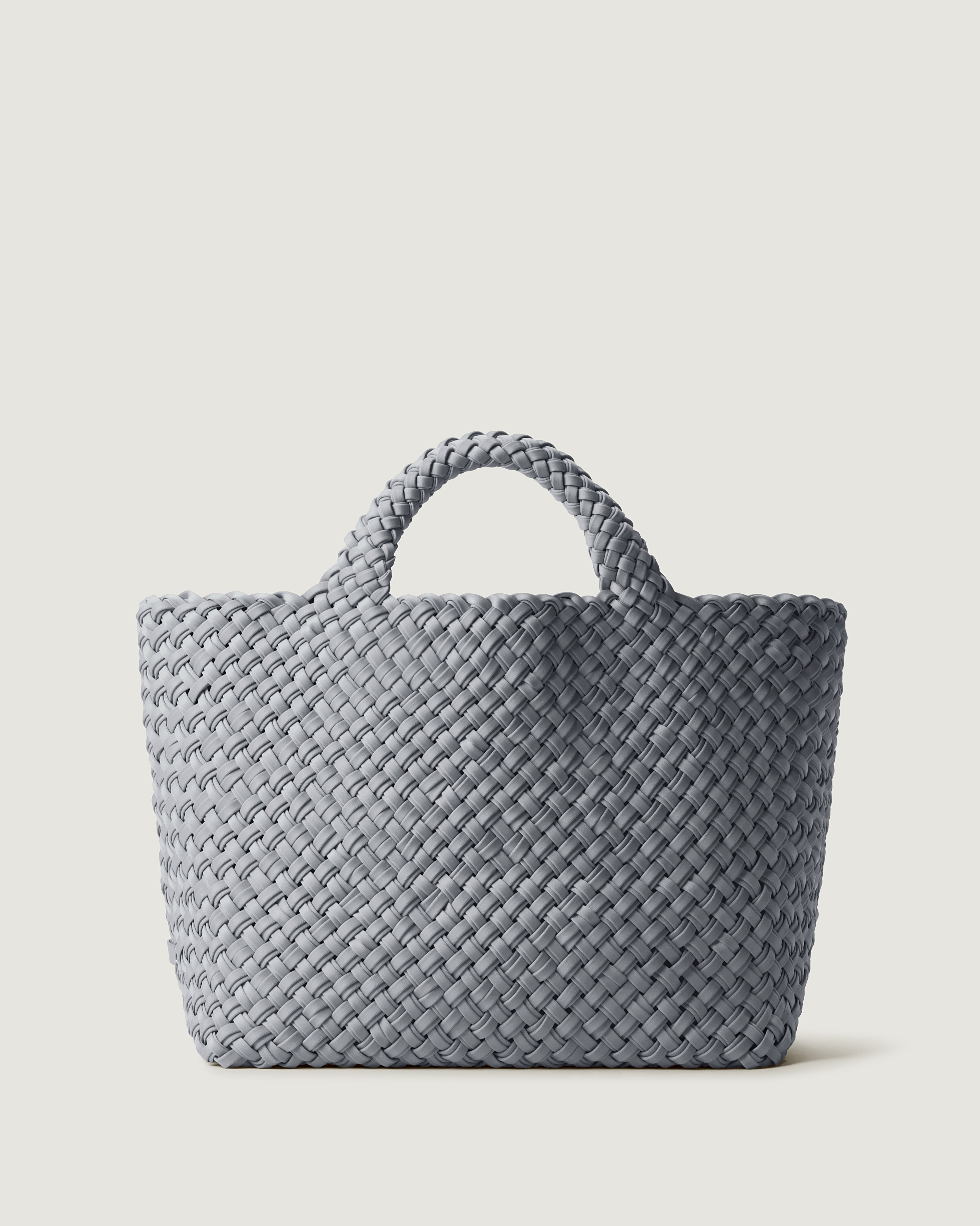 St. Barths Tote in Marina, handwoven from doubled strands of grey blue neoprene. Featuring an open top and woven handles.